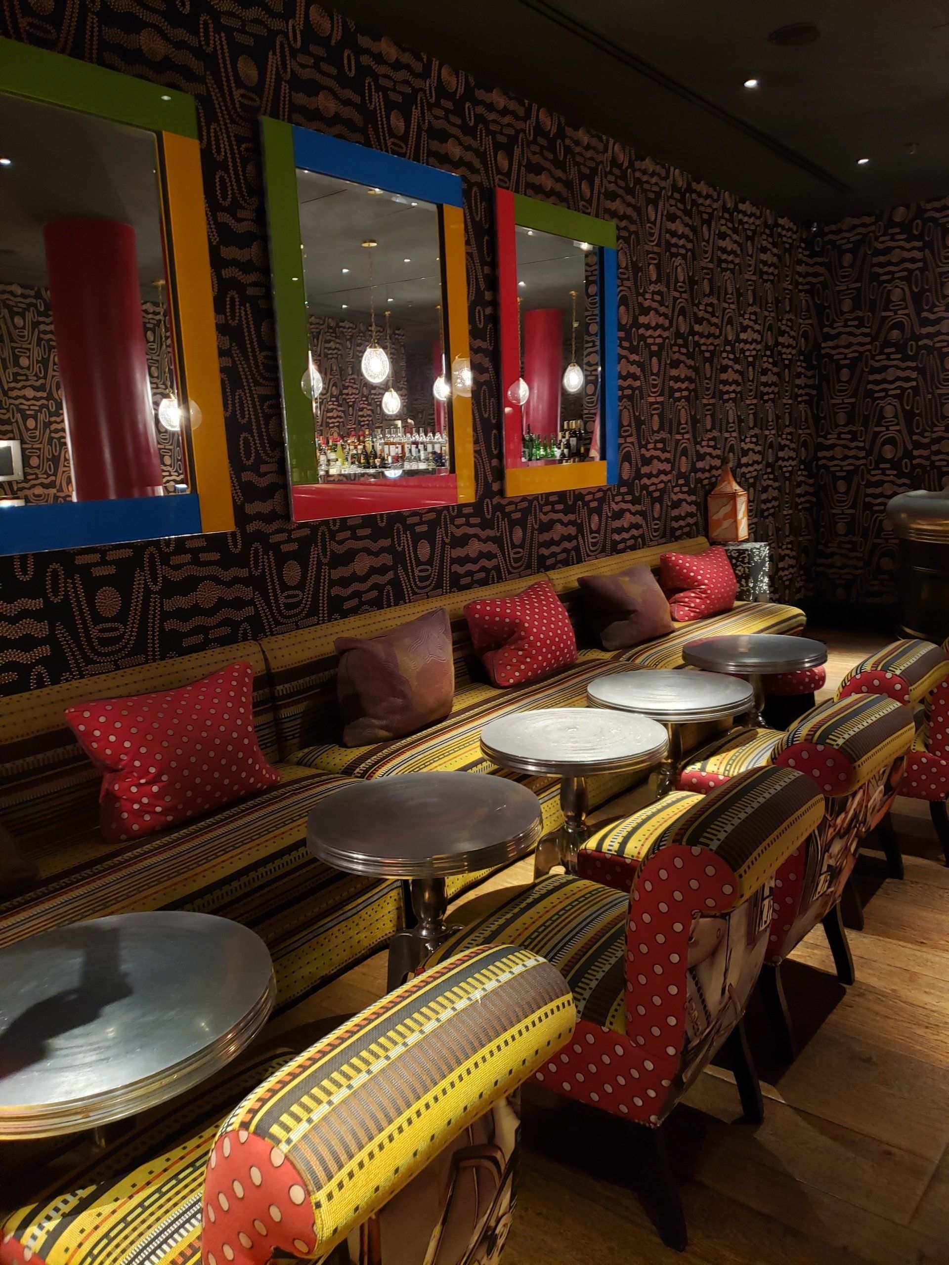 A room with tables and chairs and mirrors on the wall