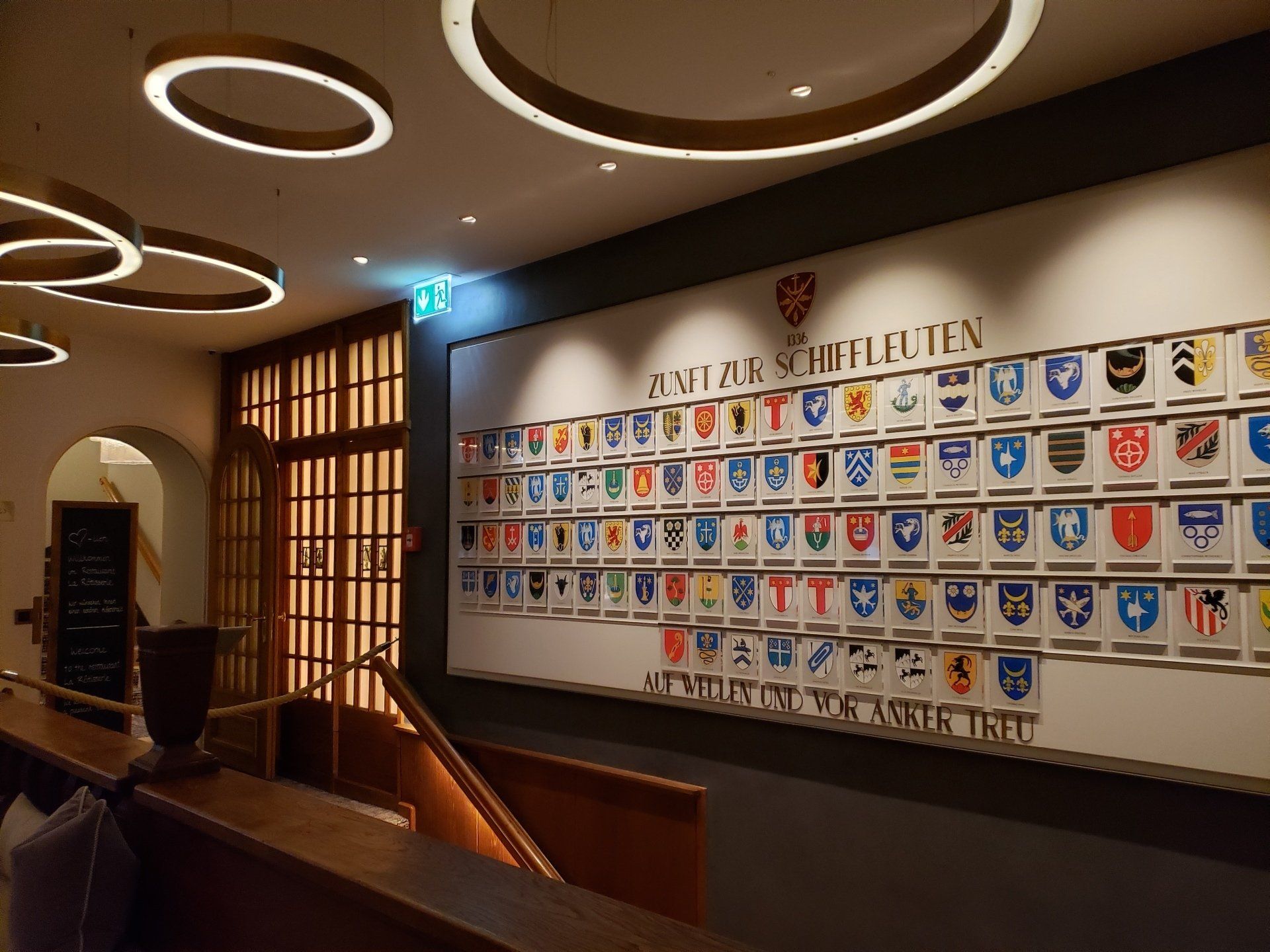 A wall with a lot of flags and shields on it