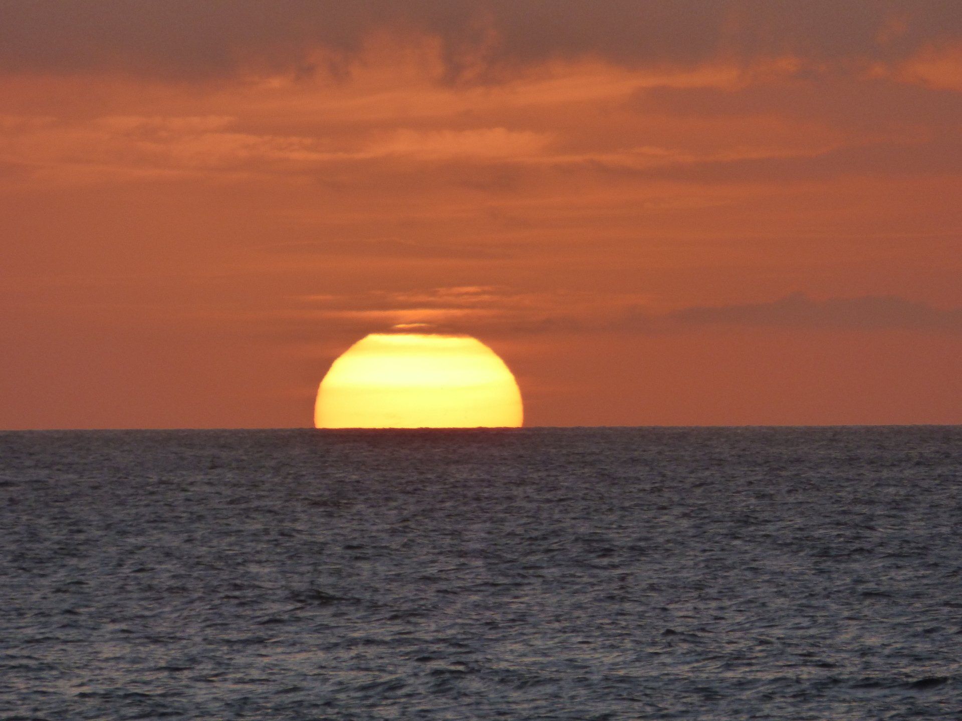 The sun is setting over the ocean.