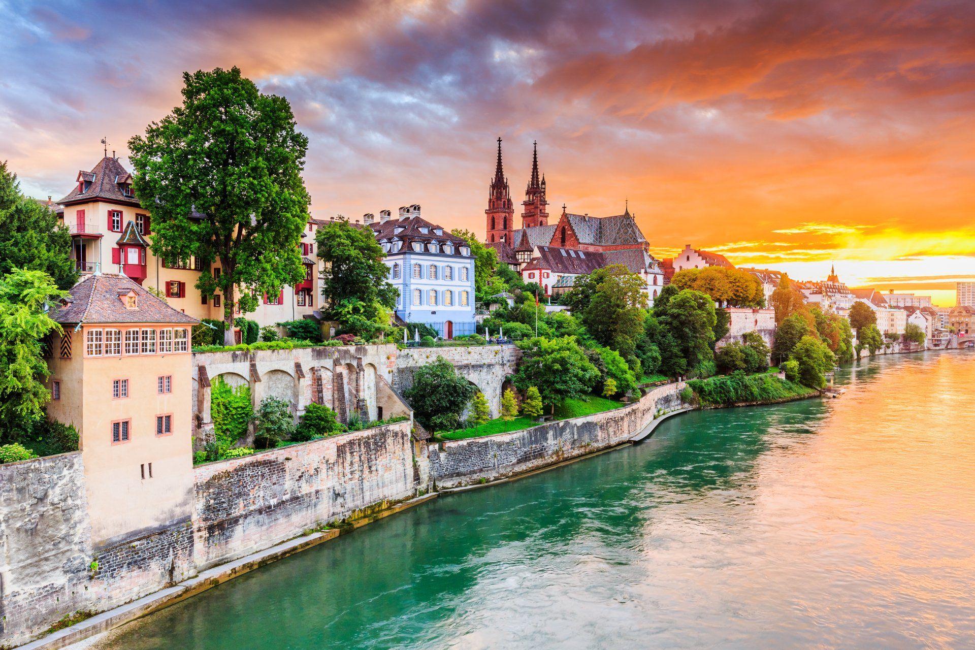 A river with a city in the background at sunset.