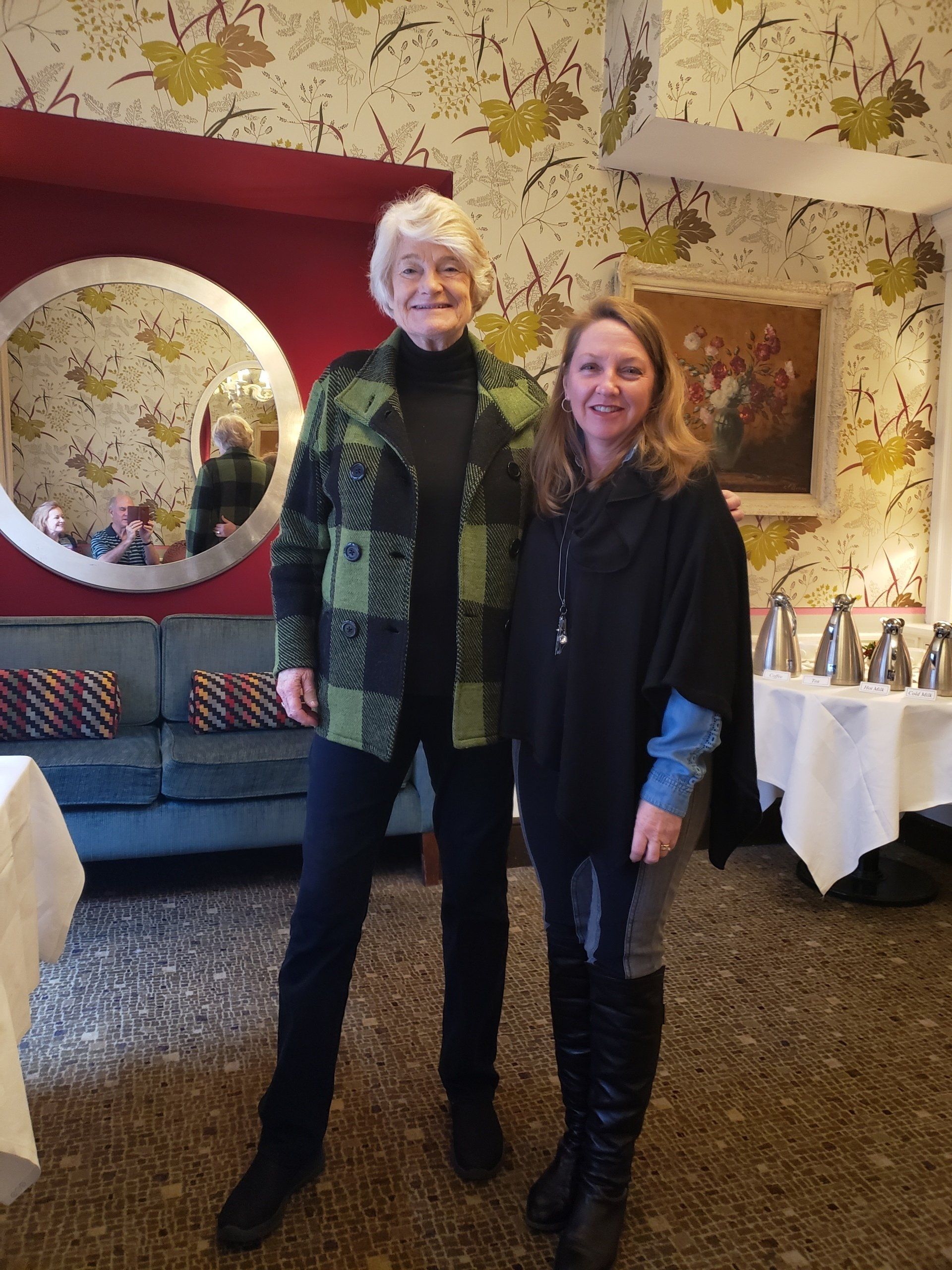 Two women are standing next to each other in a room.
