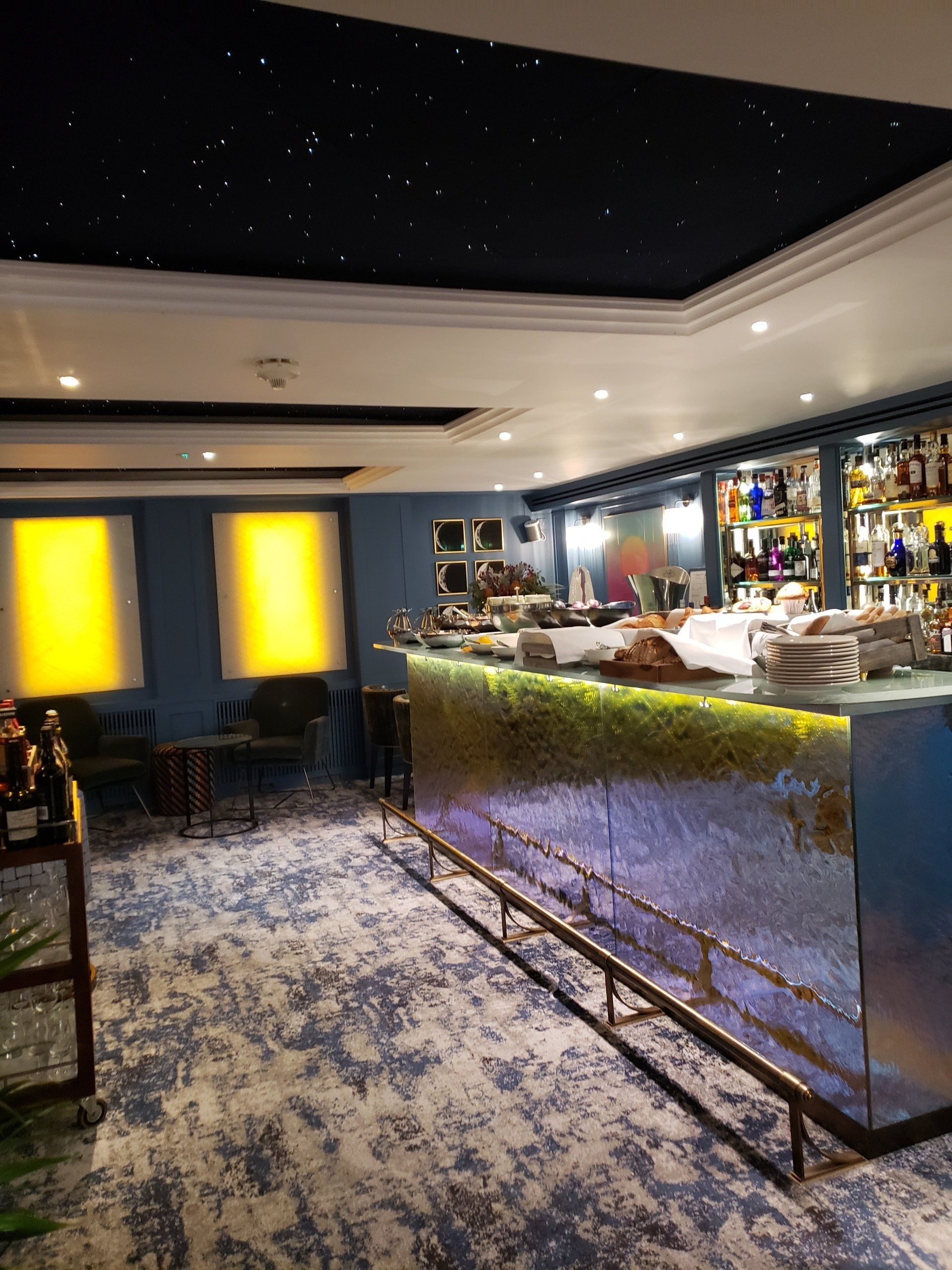 A long bar in a restaurant with a starry sky in the background.