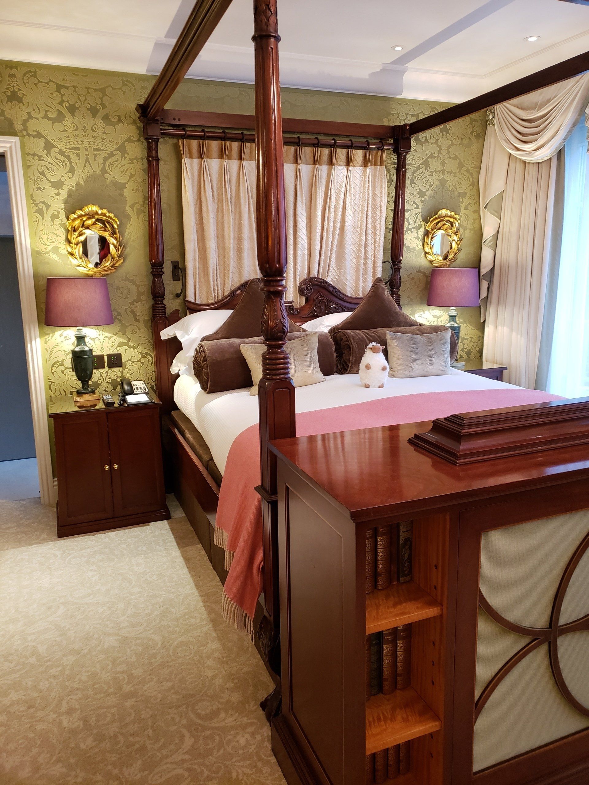 A bedroom with a four poster bed and two nightstands