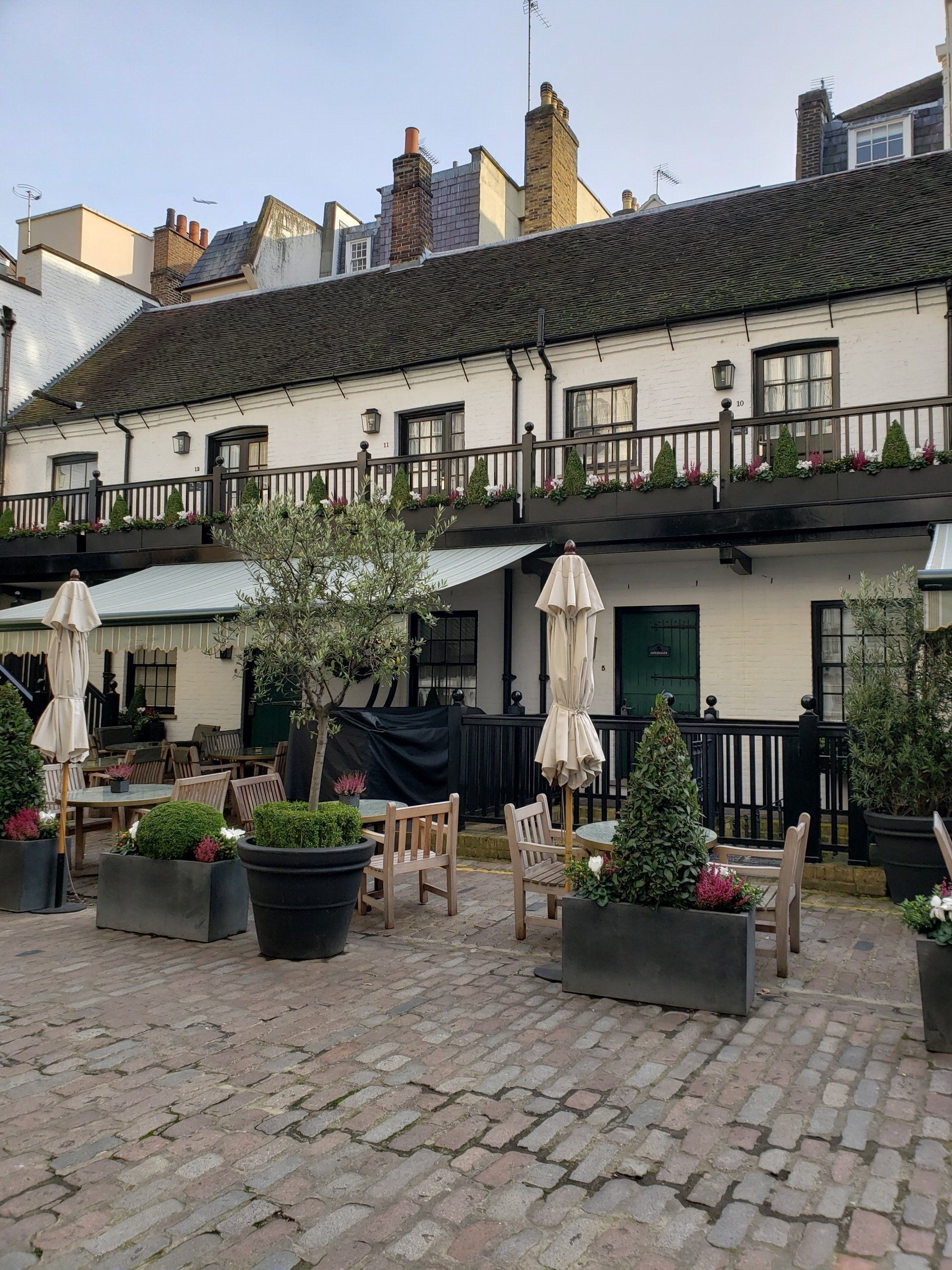 A brick courtyard with tables and chairs in front of a building