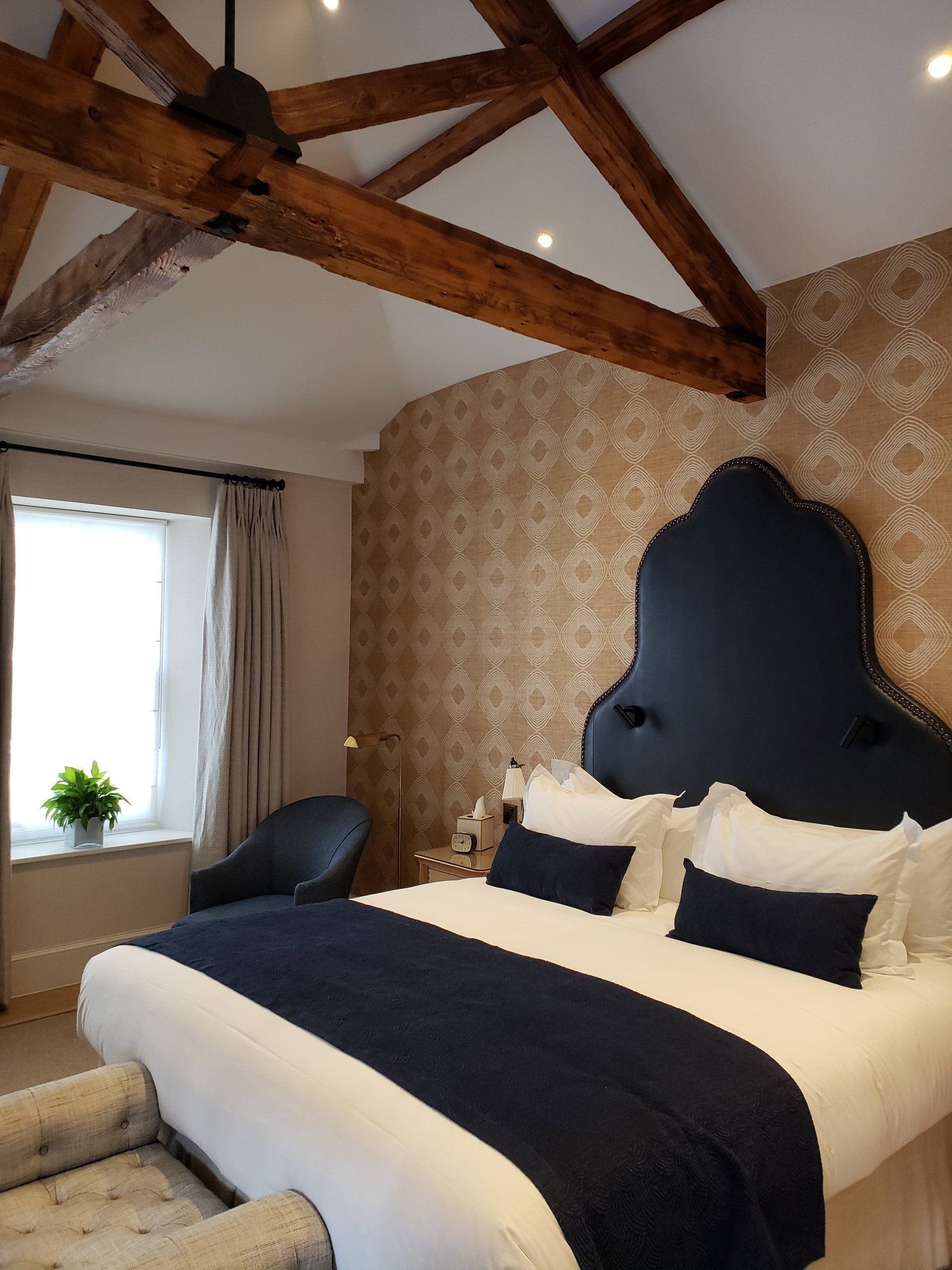 A bedroom with a large bed and a chair