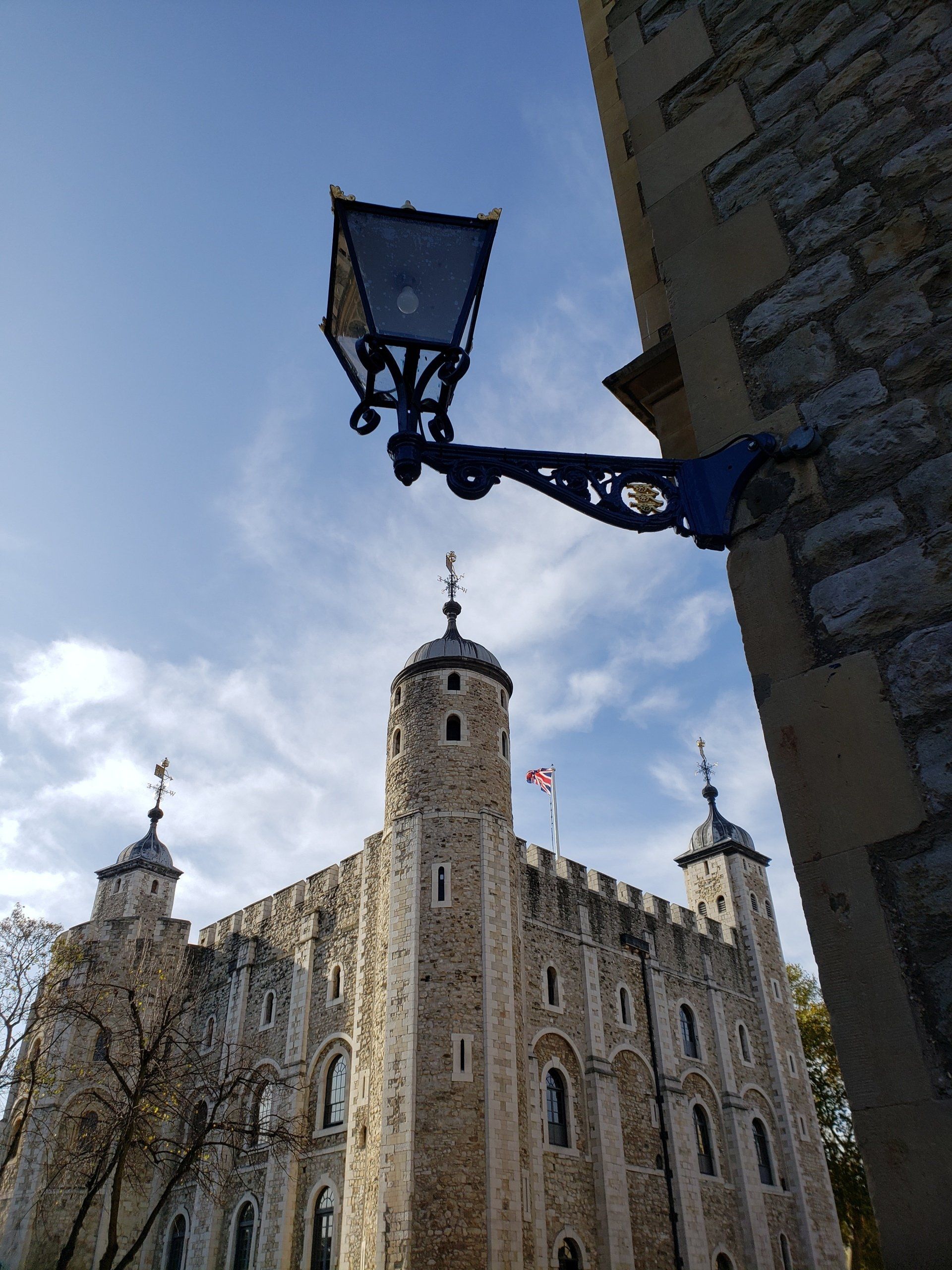 A lamp is hanging from a building next to a castle