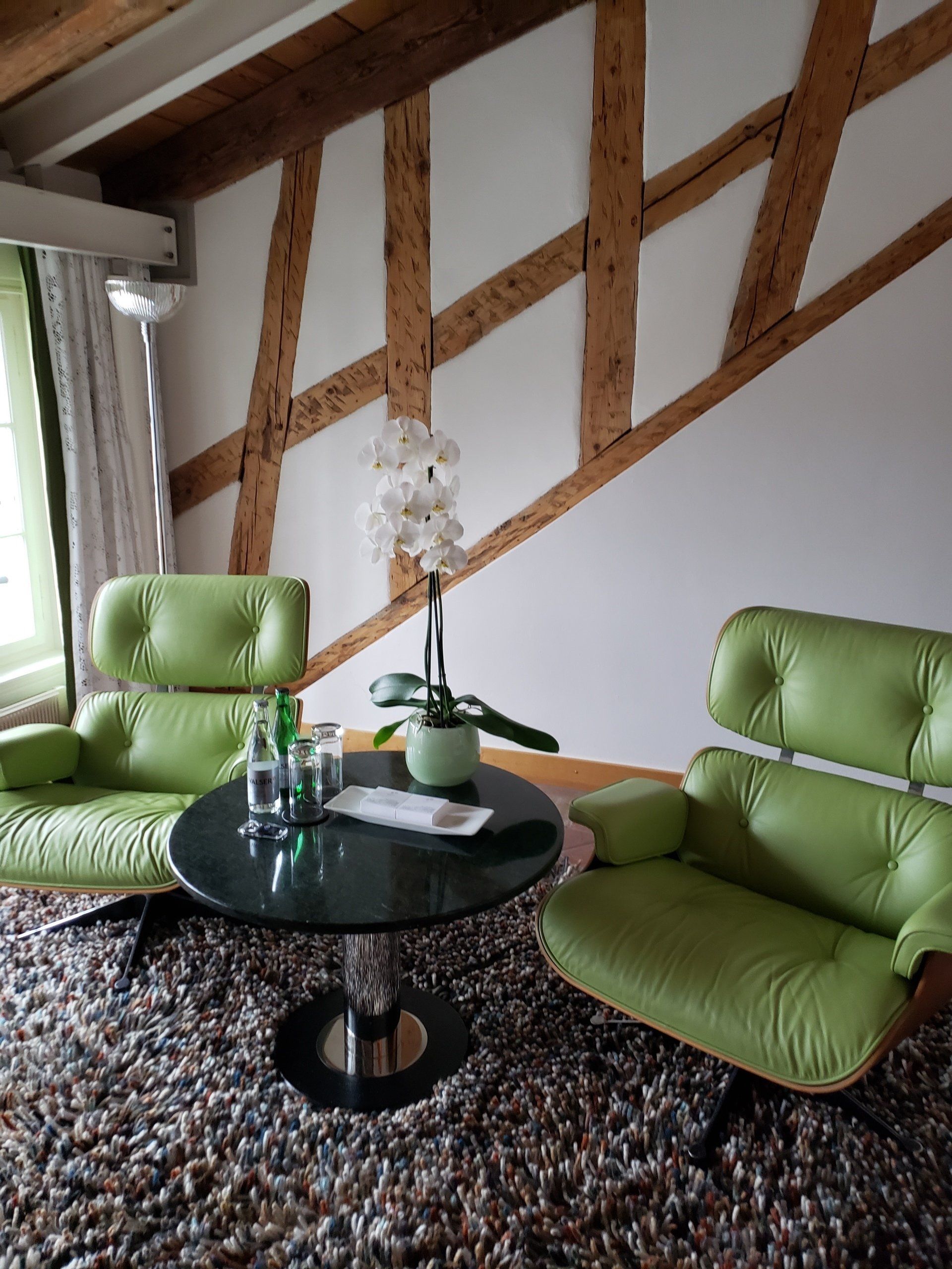 A living room with two green chairs and a table