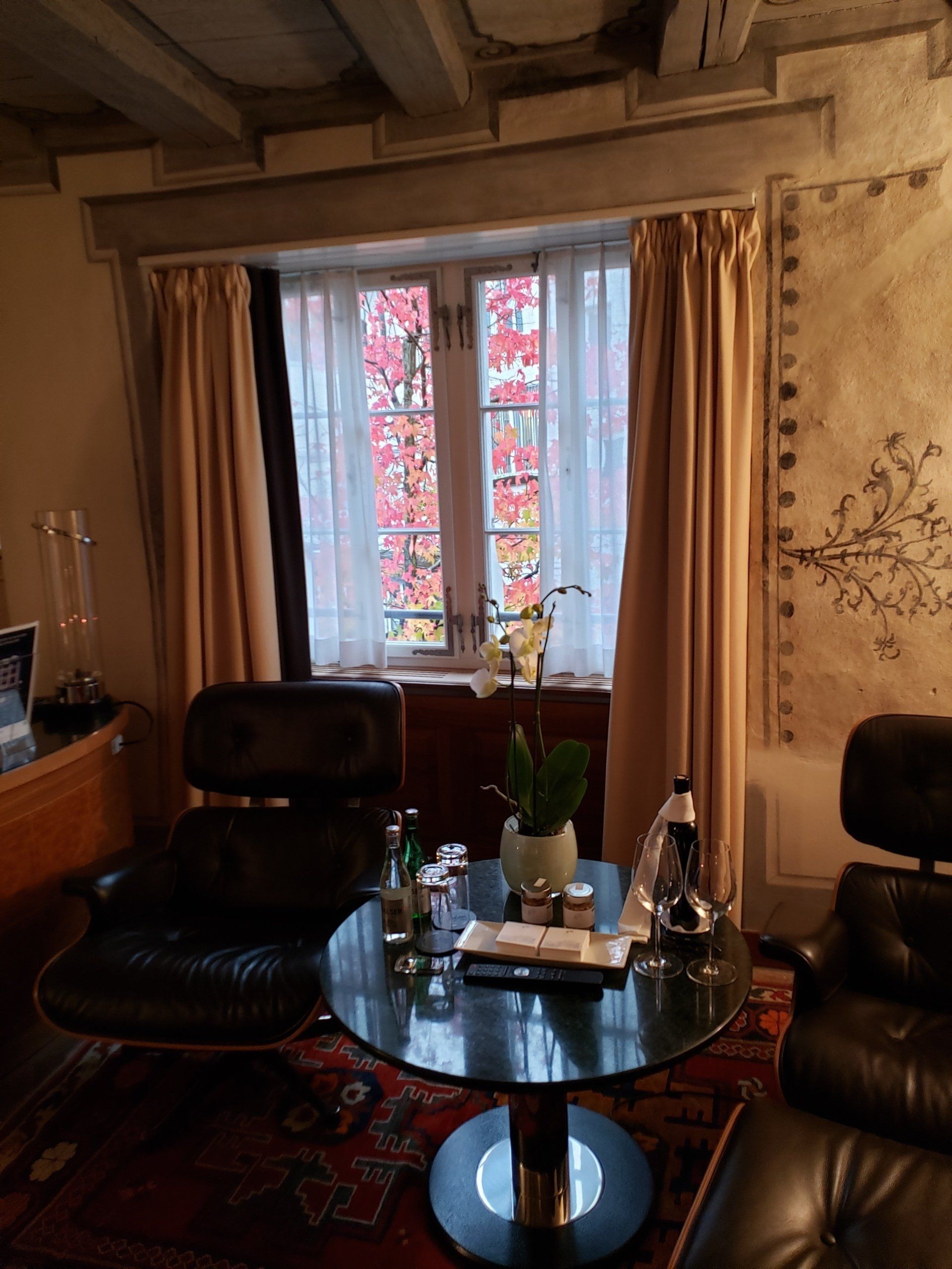 A living room with a table and chairs in front of a window