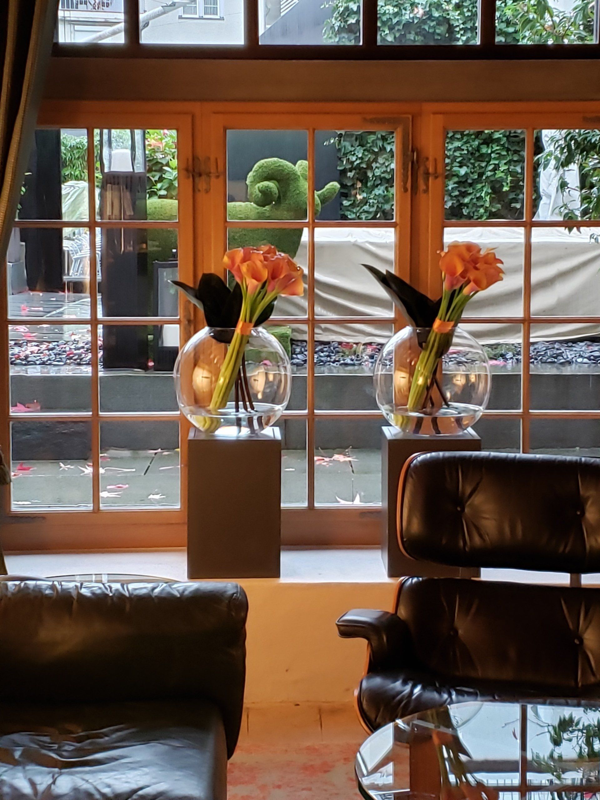 A living room with two vases of flowers in front of a window