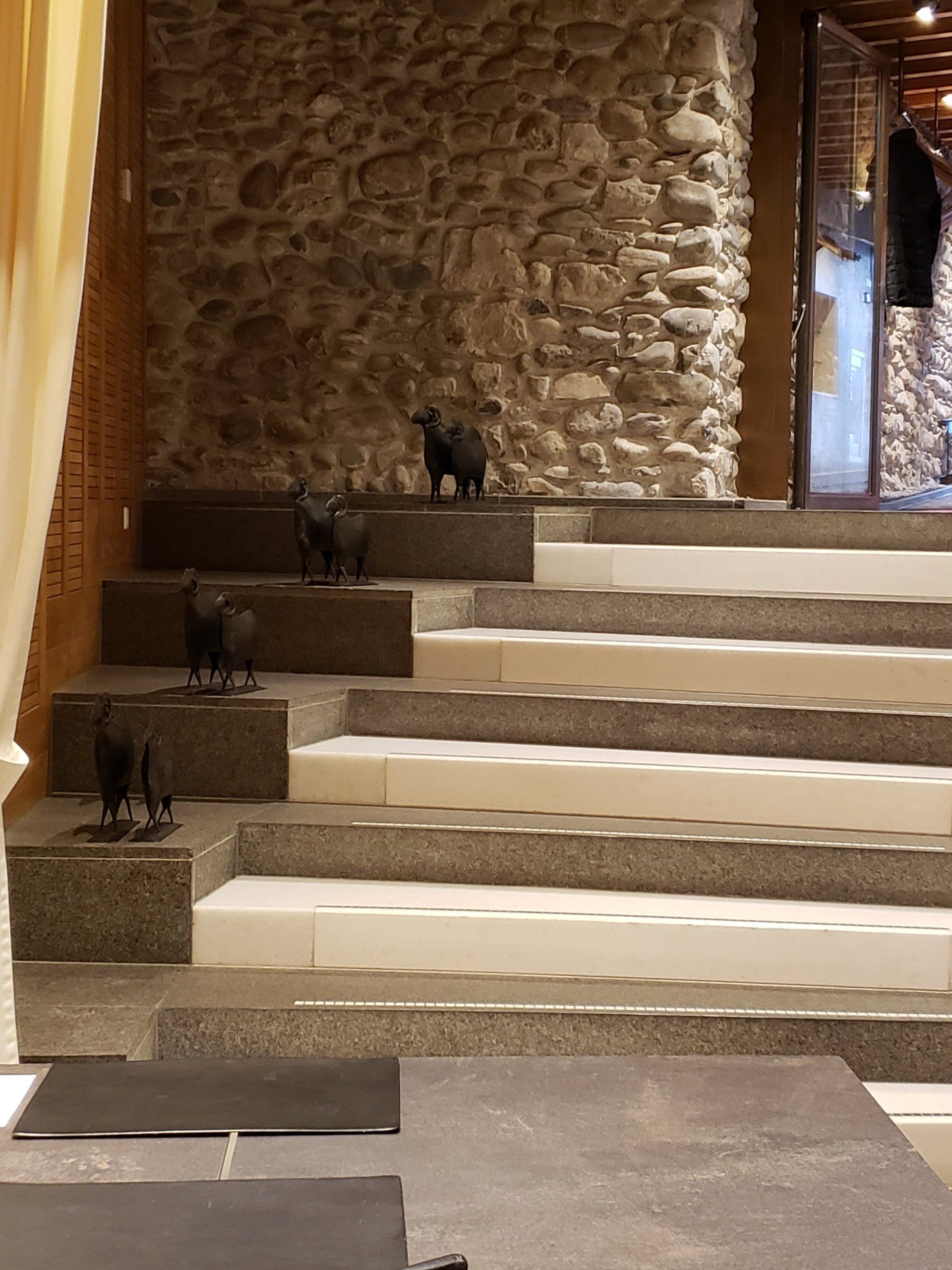 A set of stairs with a stone wall in the background