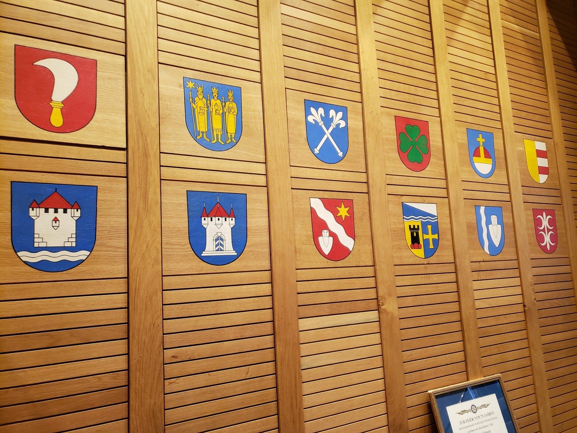 A wall with a lot of coats of arms on it
