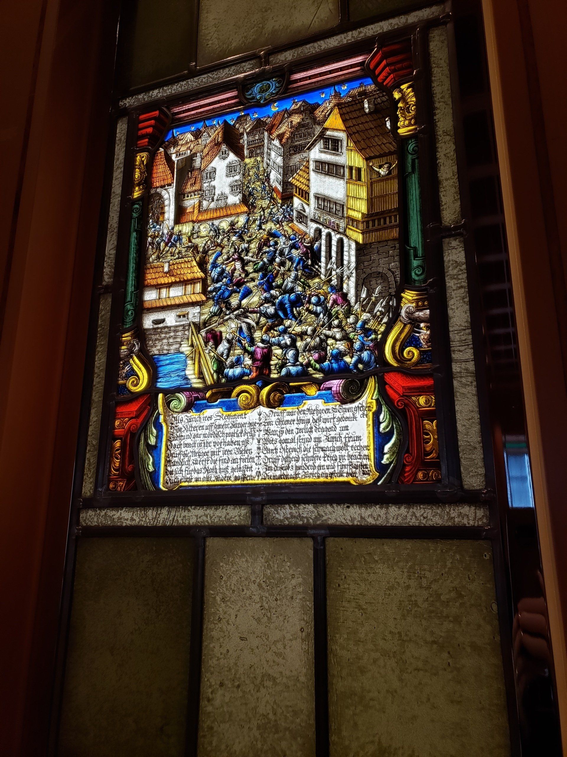 A stained glass window with a picture of a crowd of people