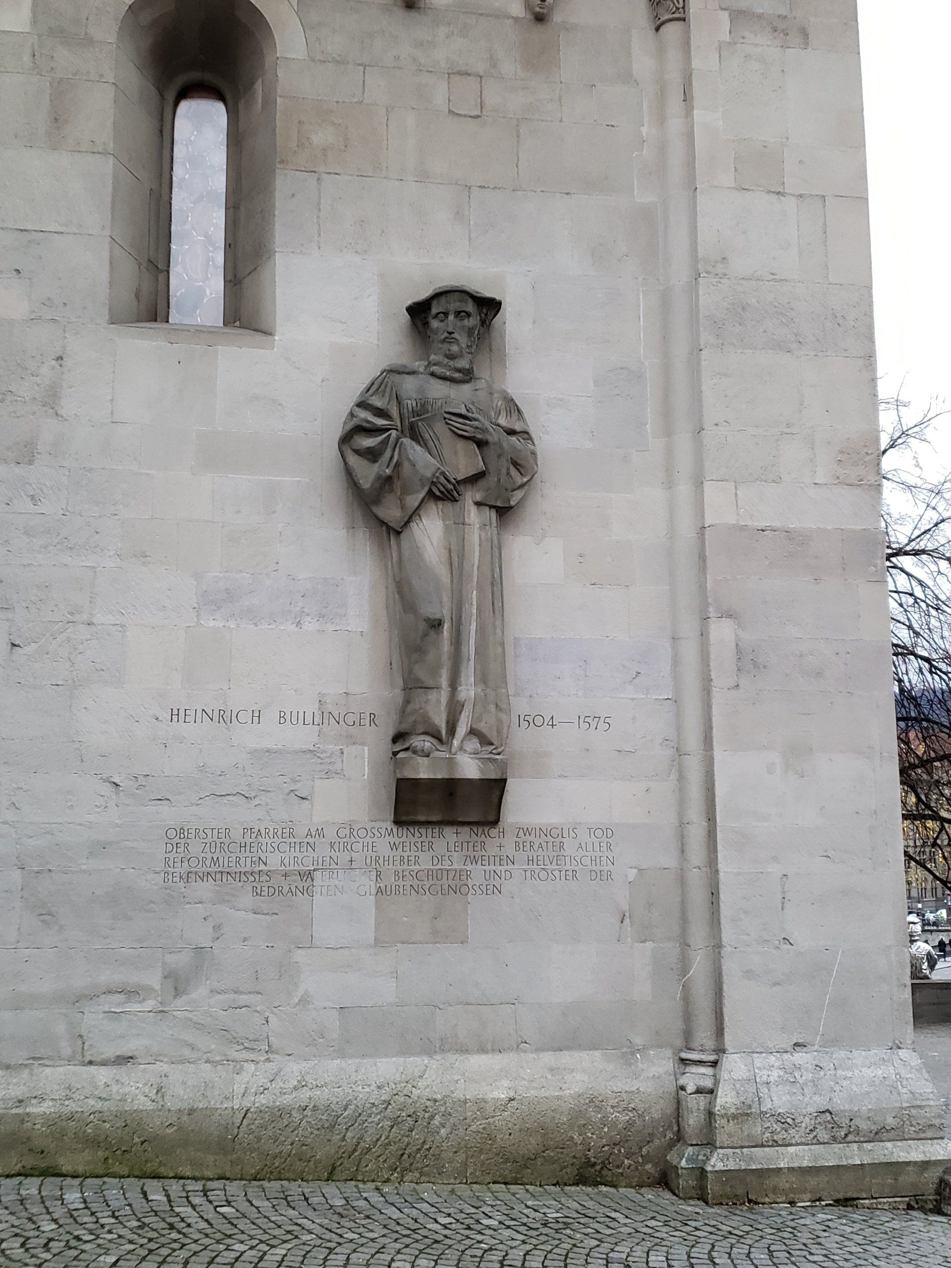 A statue of a man is on the side of a building