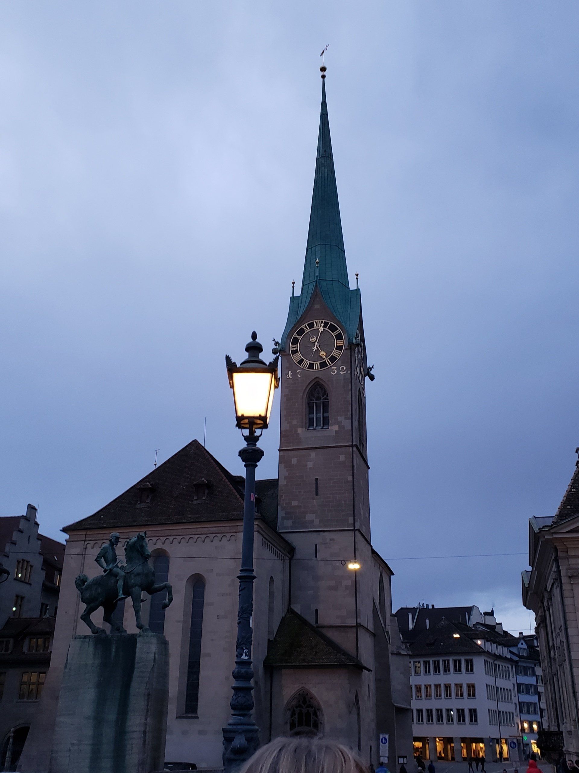 A church with a clock tower and a lamp post in front of it