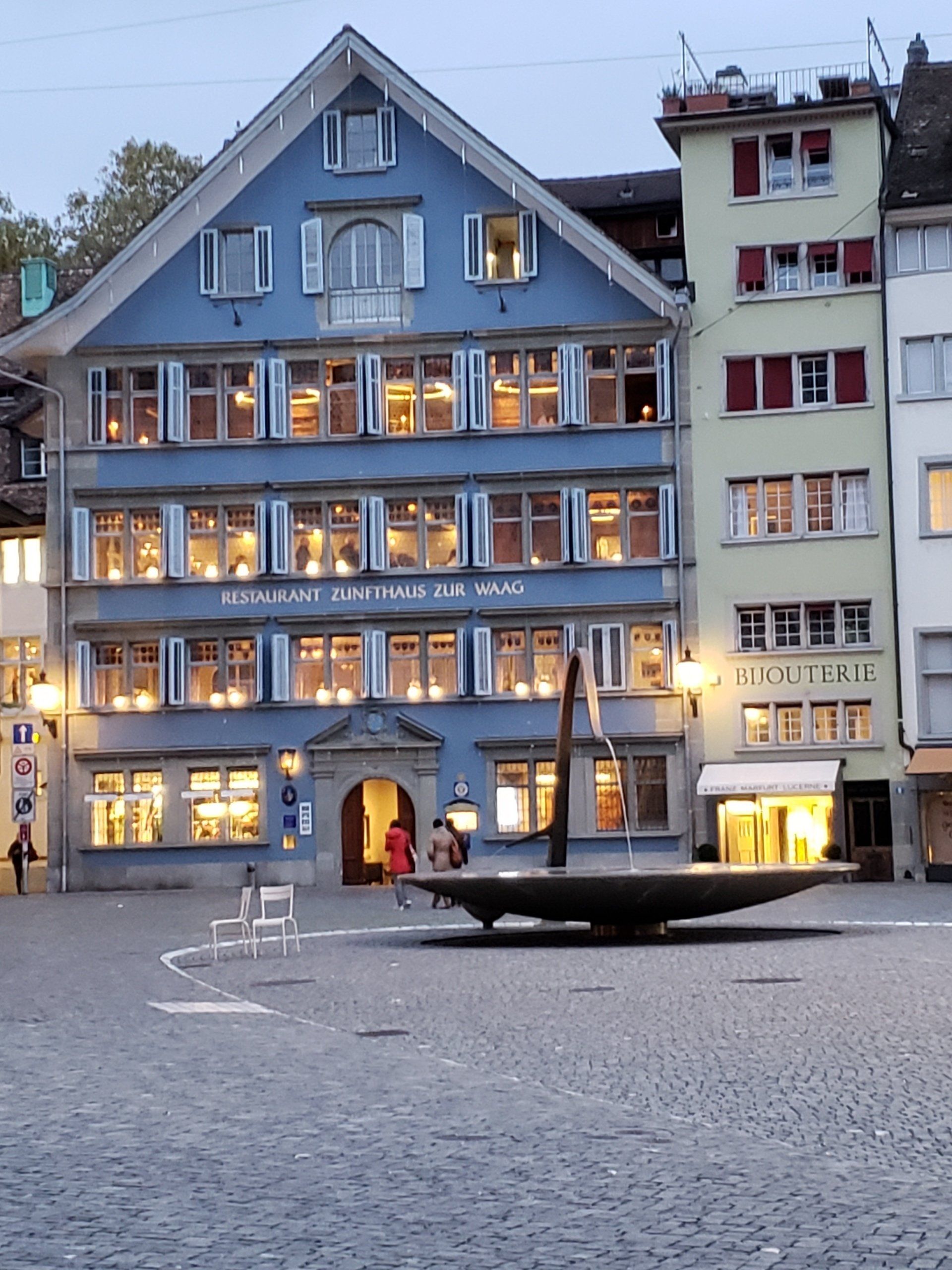 A blue building with a fountain in front of it