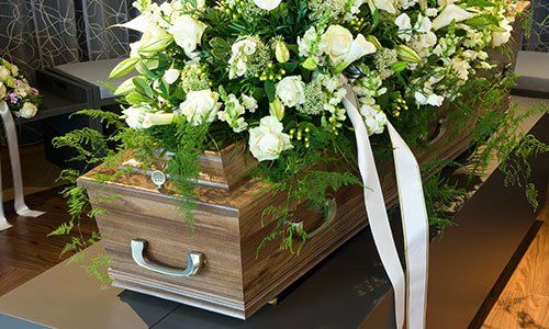 una bara con delle rose bianche sopra 