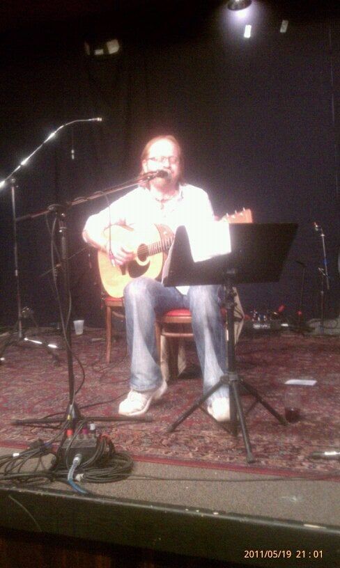 Man in white polo playing with music stand