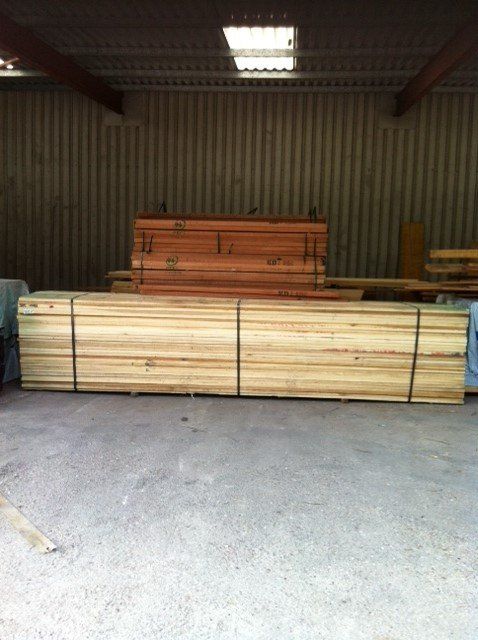 timber beams stacked up and bound in warehouse