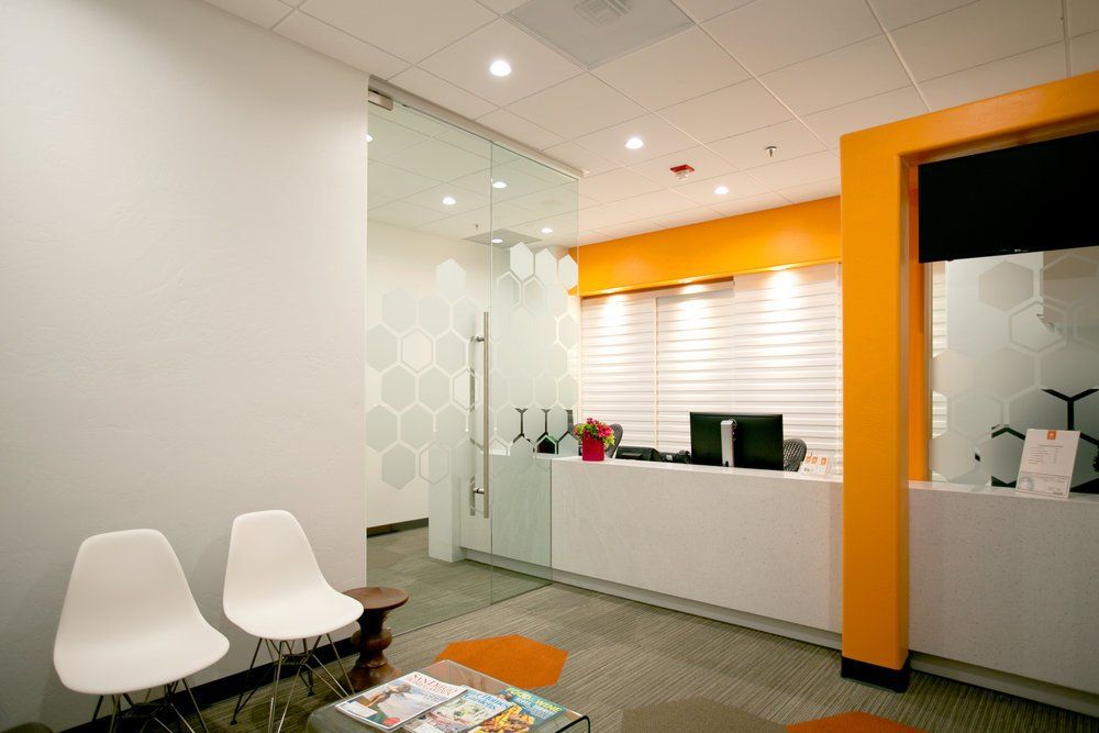 A waiting room with chairs , a table , and a desk.