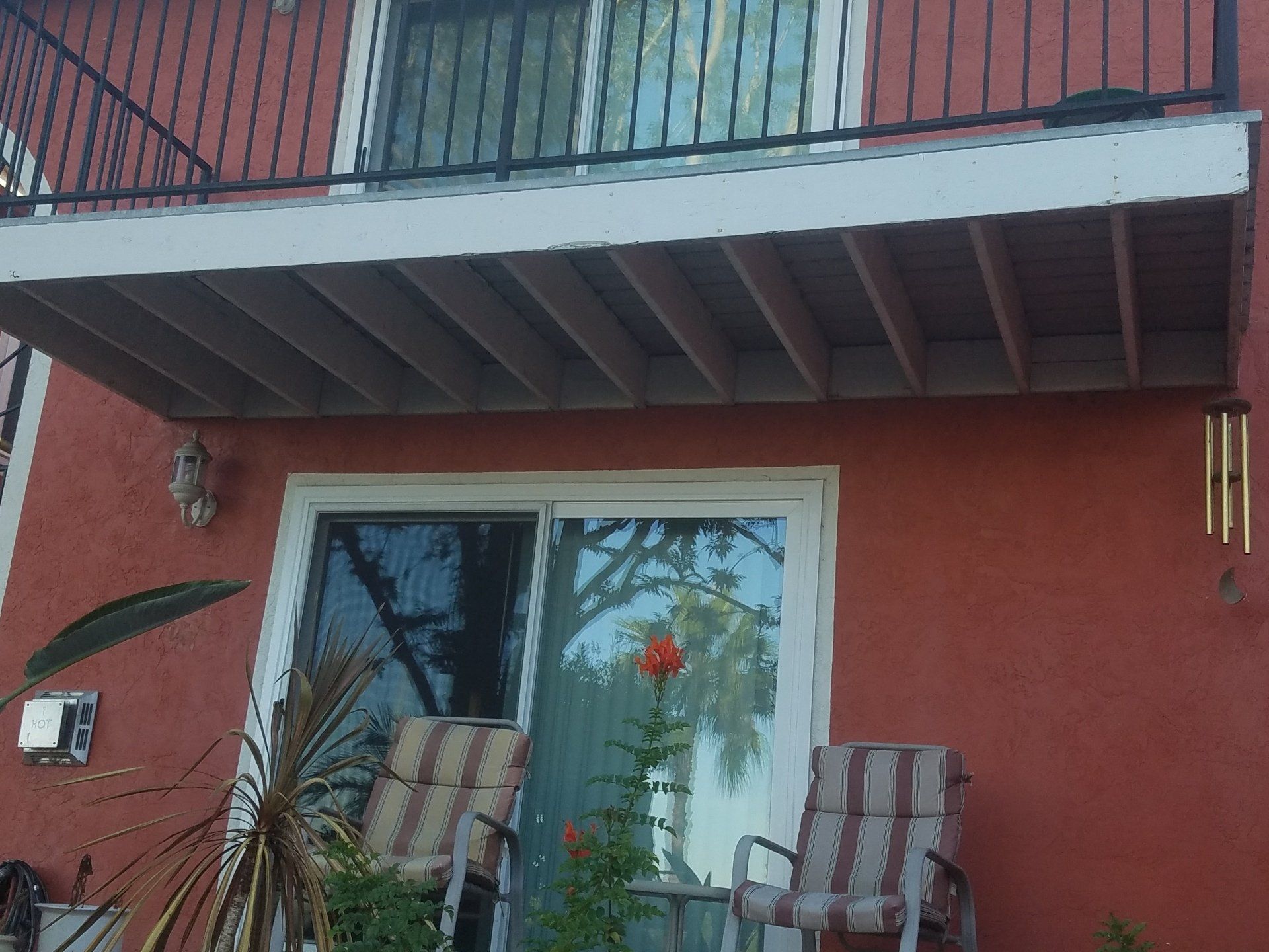 A red building with a sliding glass door and a balcony