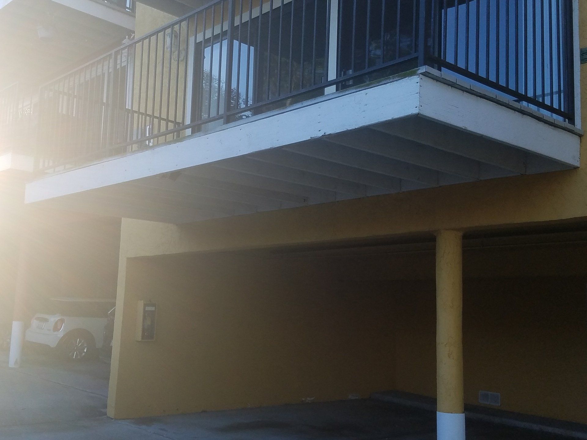 A yellow building with a balcony on top of it