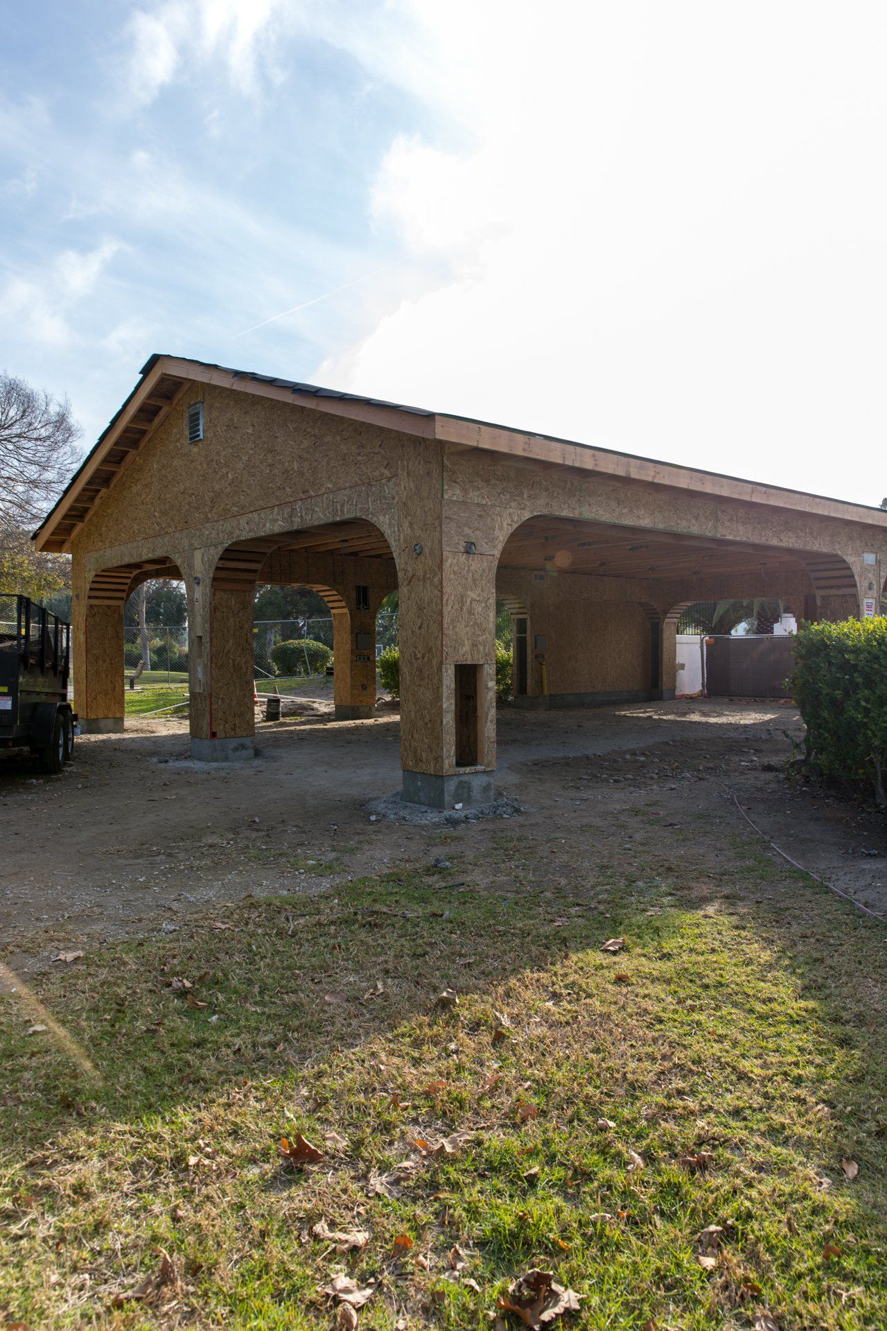 A truck is parked in front of a wooden garage under construction.