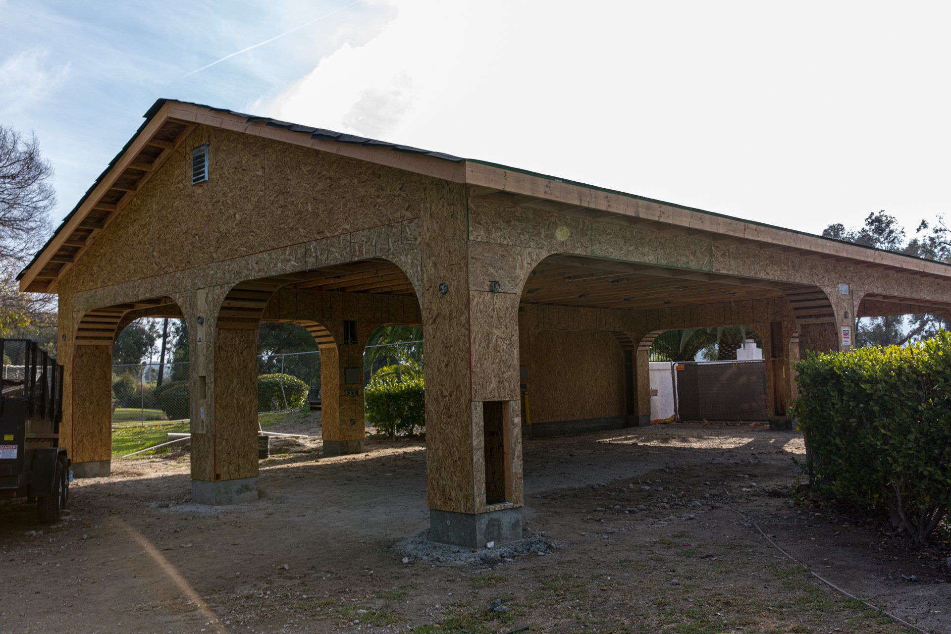 A carport is being built in the backyard of a house.