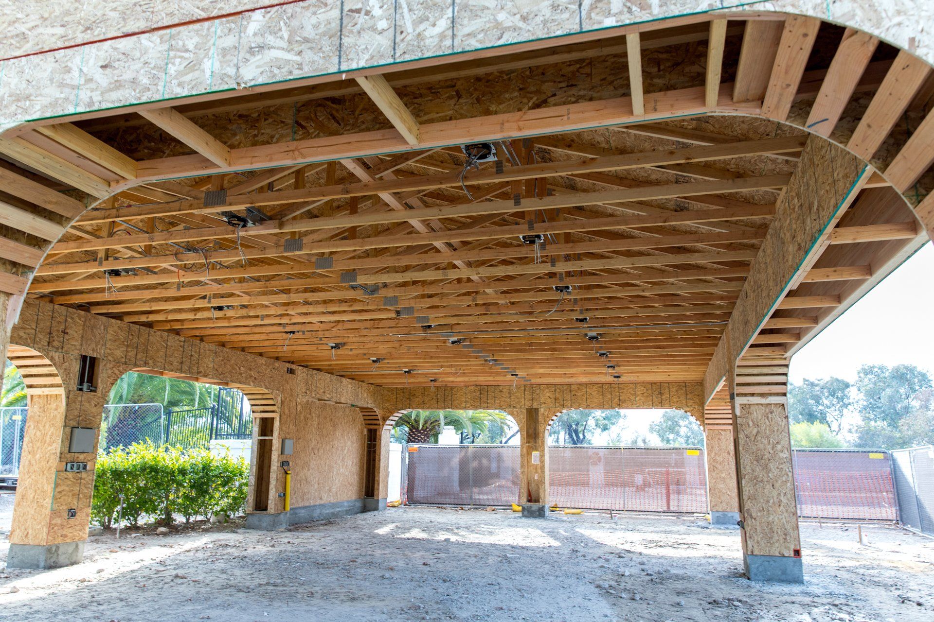 A carport is being built with wooden beams and pillars.