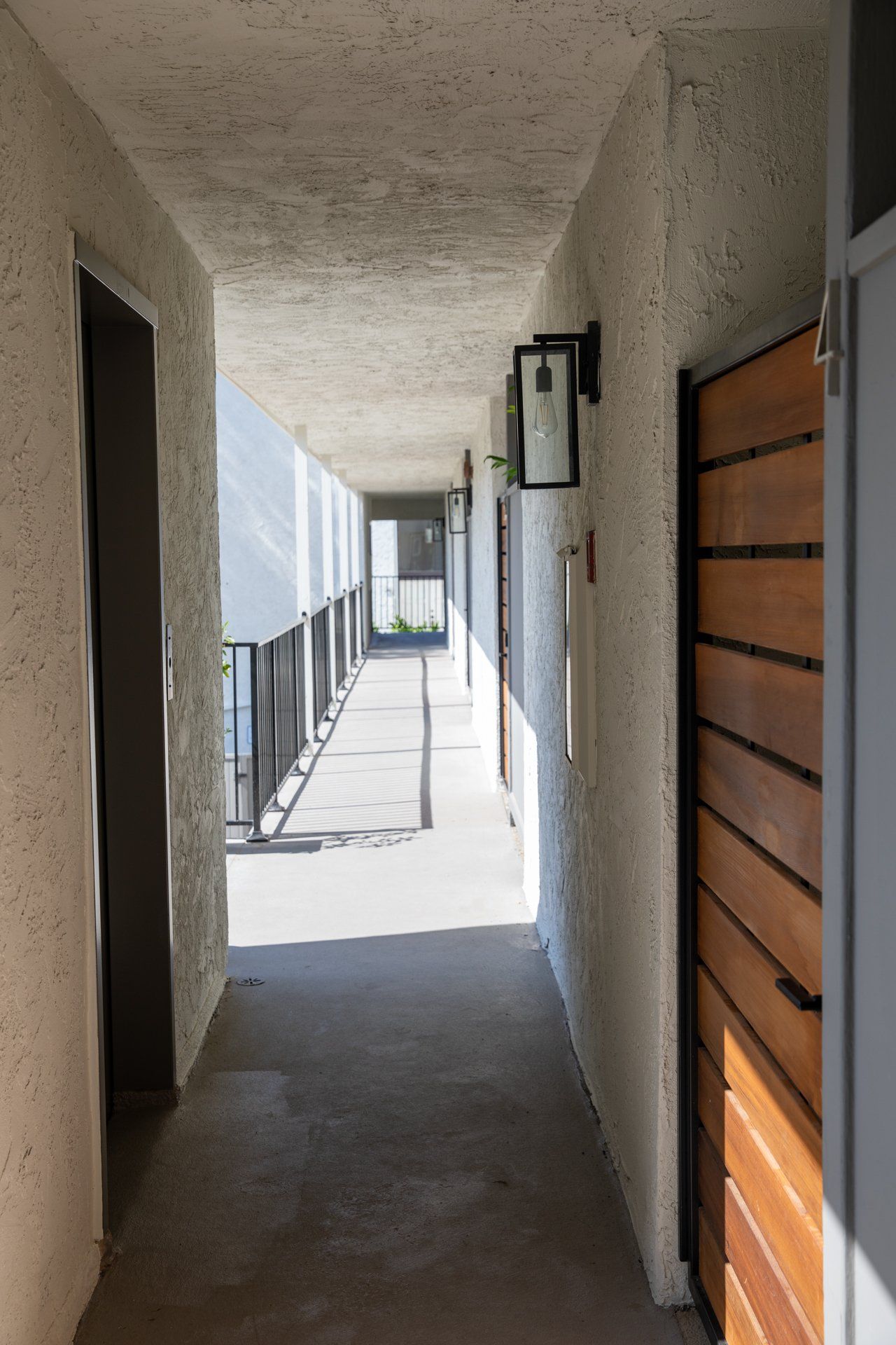 A long hallway in a building with a wooden door