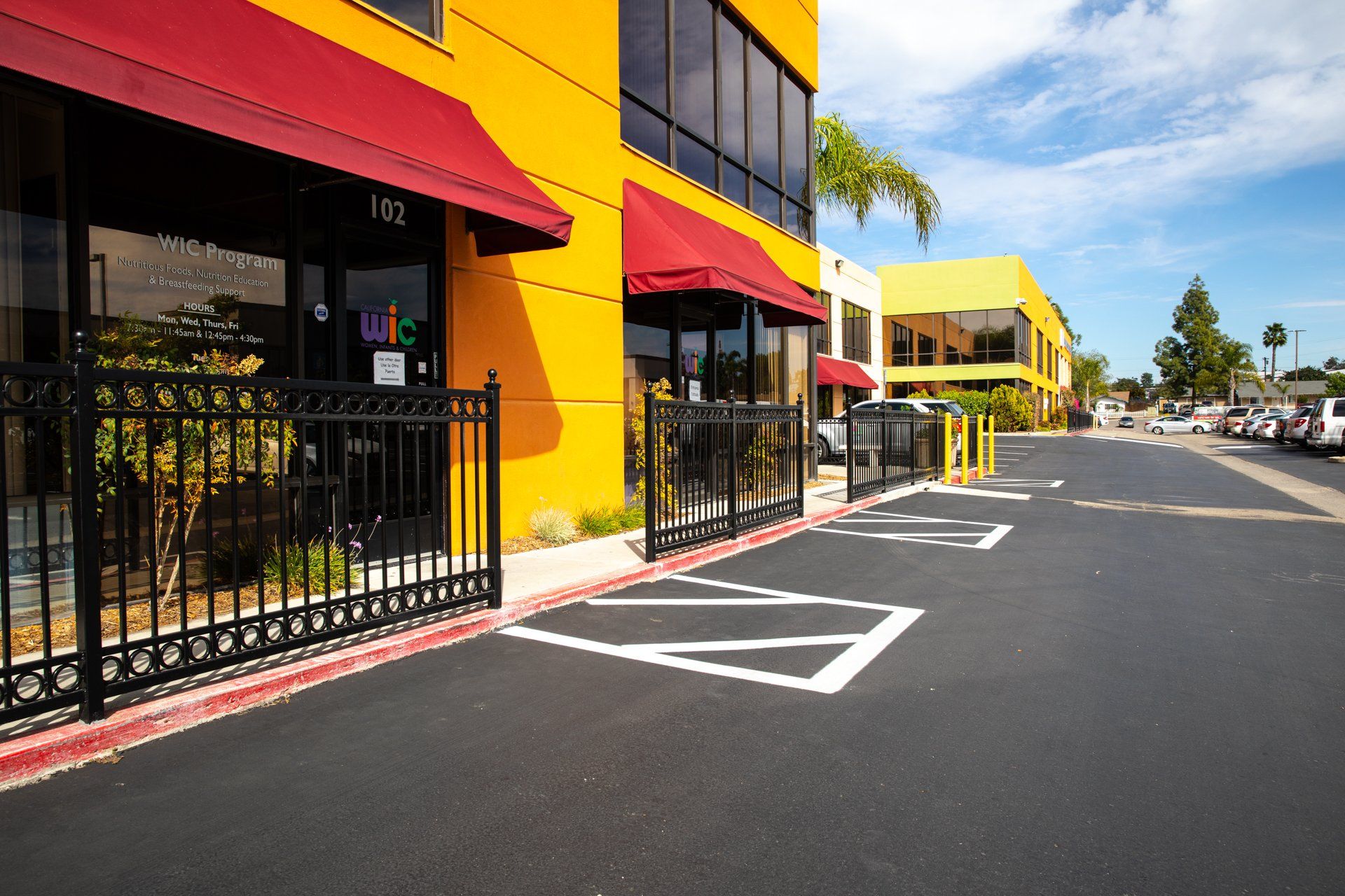 A yellow building with a red awning on the side of it