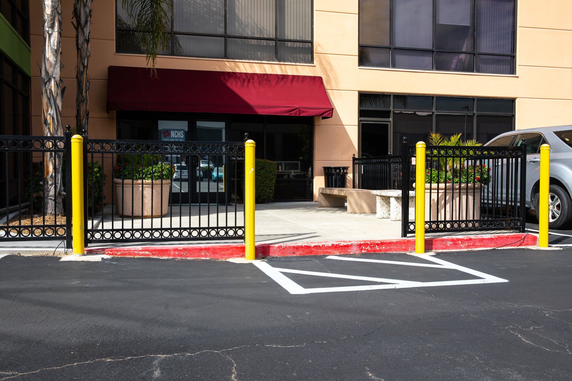 A car is parked in a handicapped parking spot in front of a building