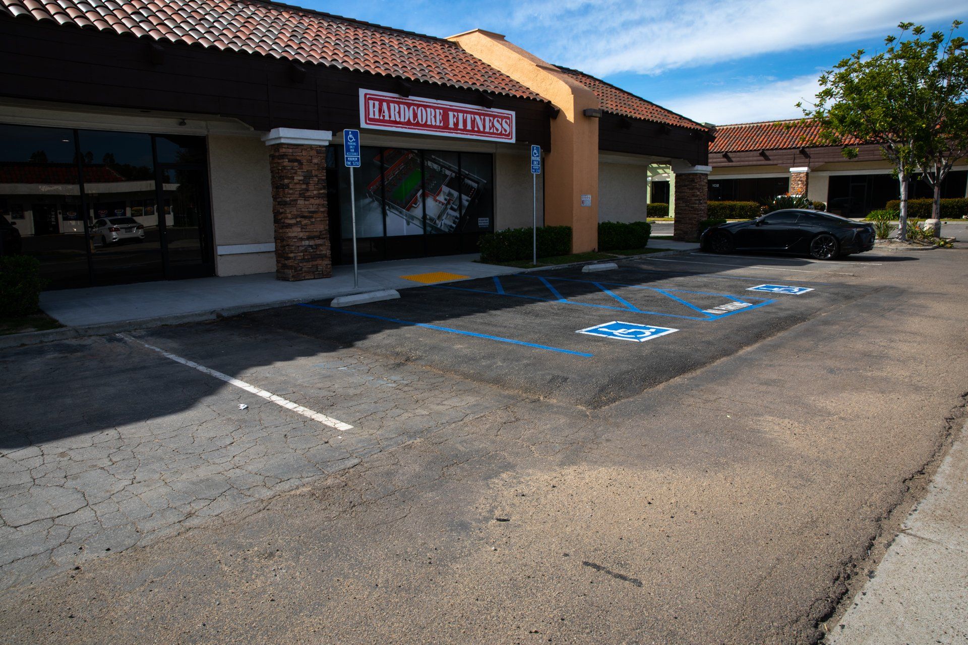 A parking lot in front of a building that has a sign that says ' too tired ' on it