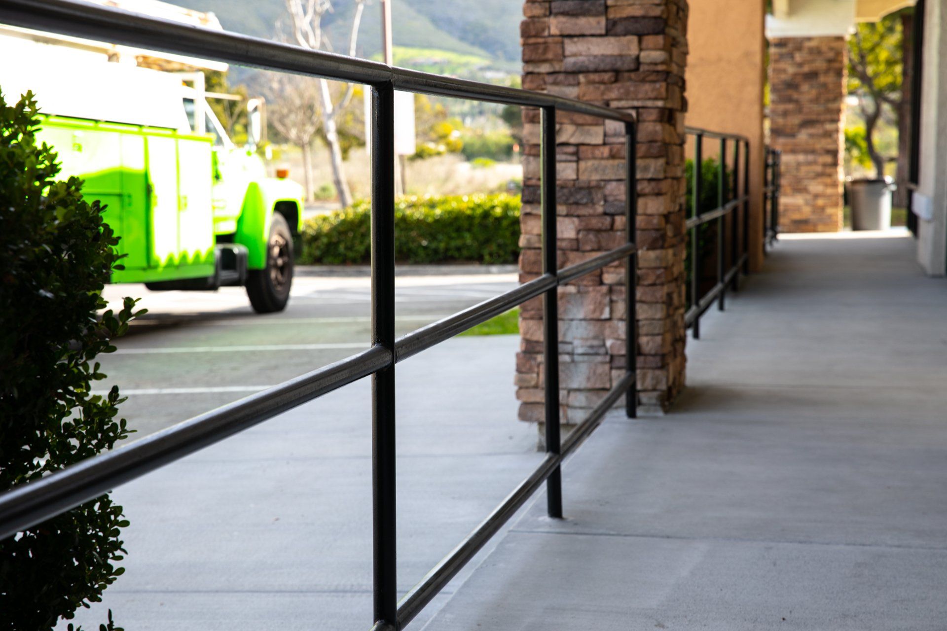 A green truck is parked in front of a building