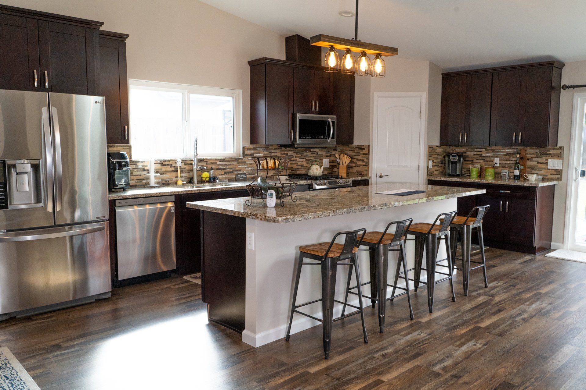 A kitchen with stainless steel appliances , granite counter tops , and a large island.