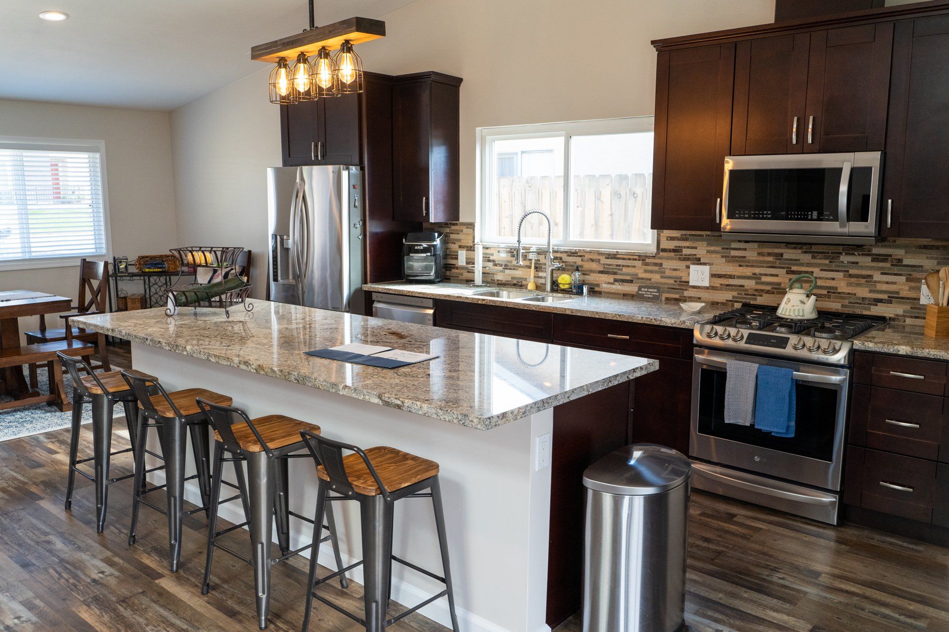 A kitchen with granite counter tops , stainless steel appliances , and a large island.