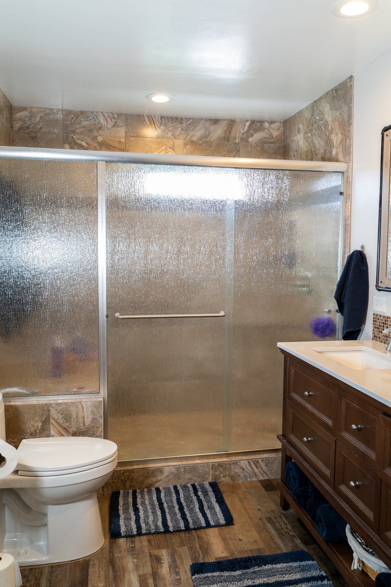 A bathroom with a toilet , sink , and walk in shower.