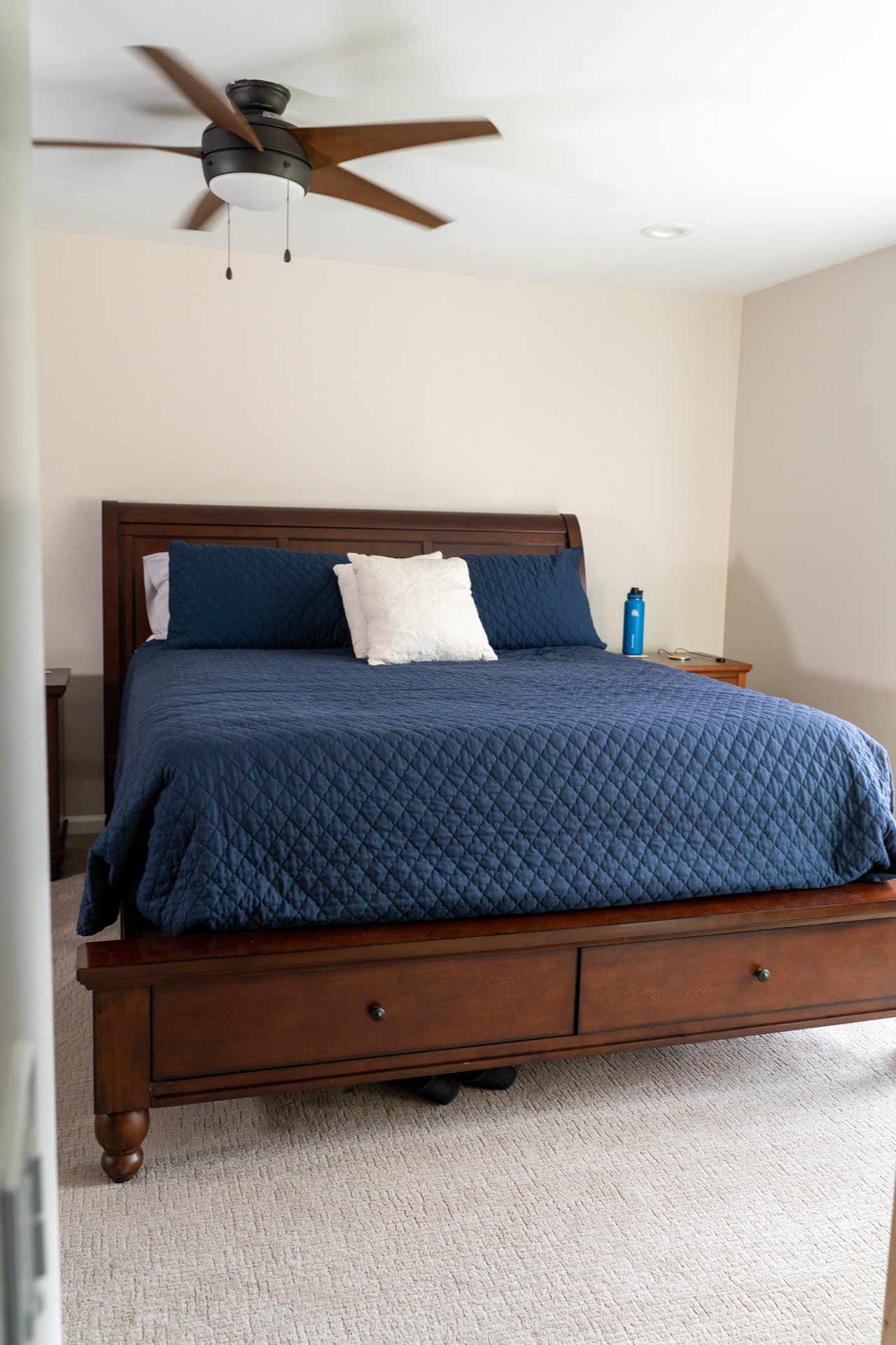 A bedroom with a king size bed and a ceiling fan.