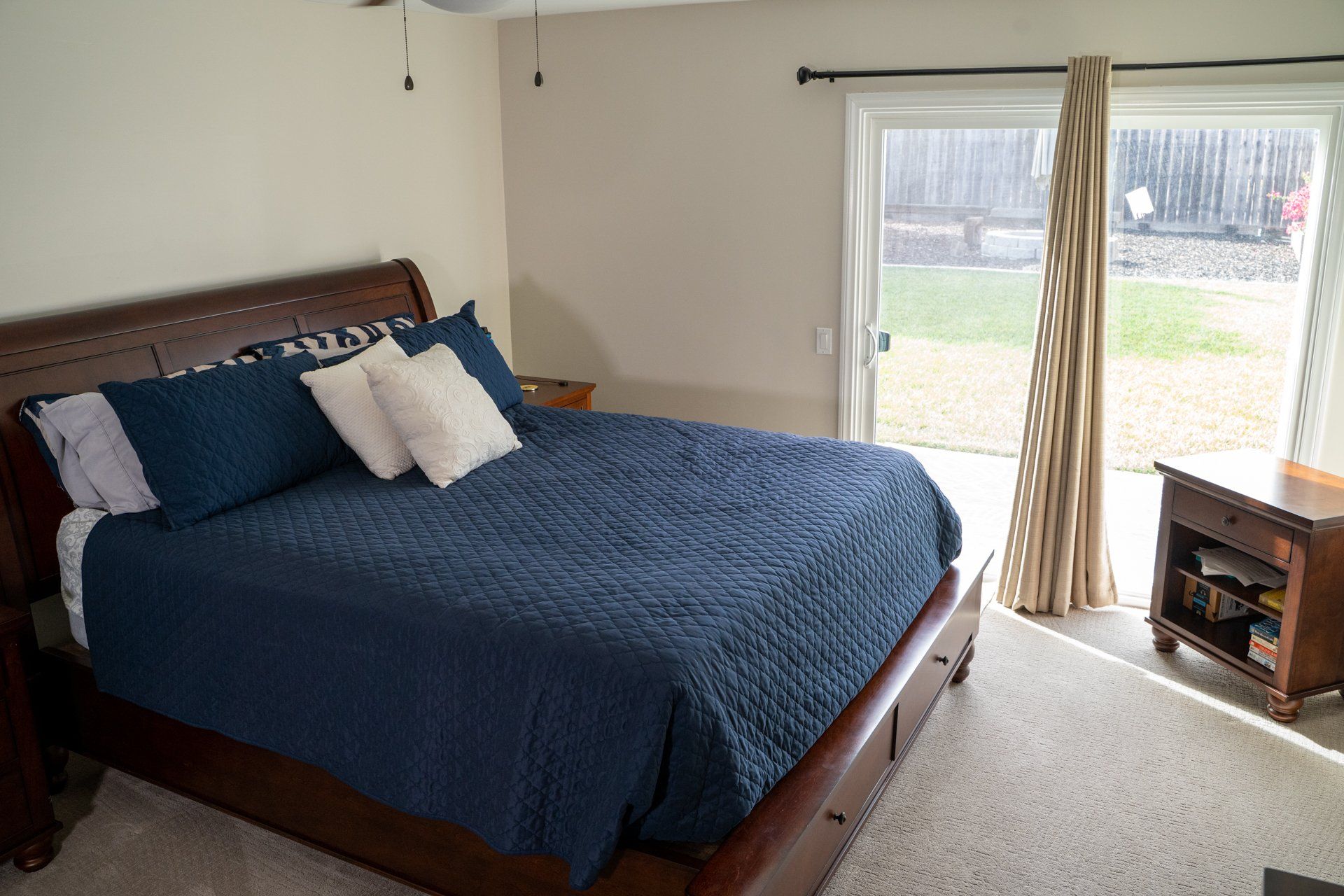 A bedroom with a large bed and a sliding glass door.
