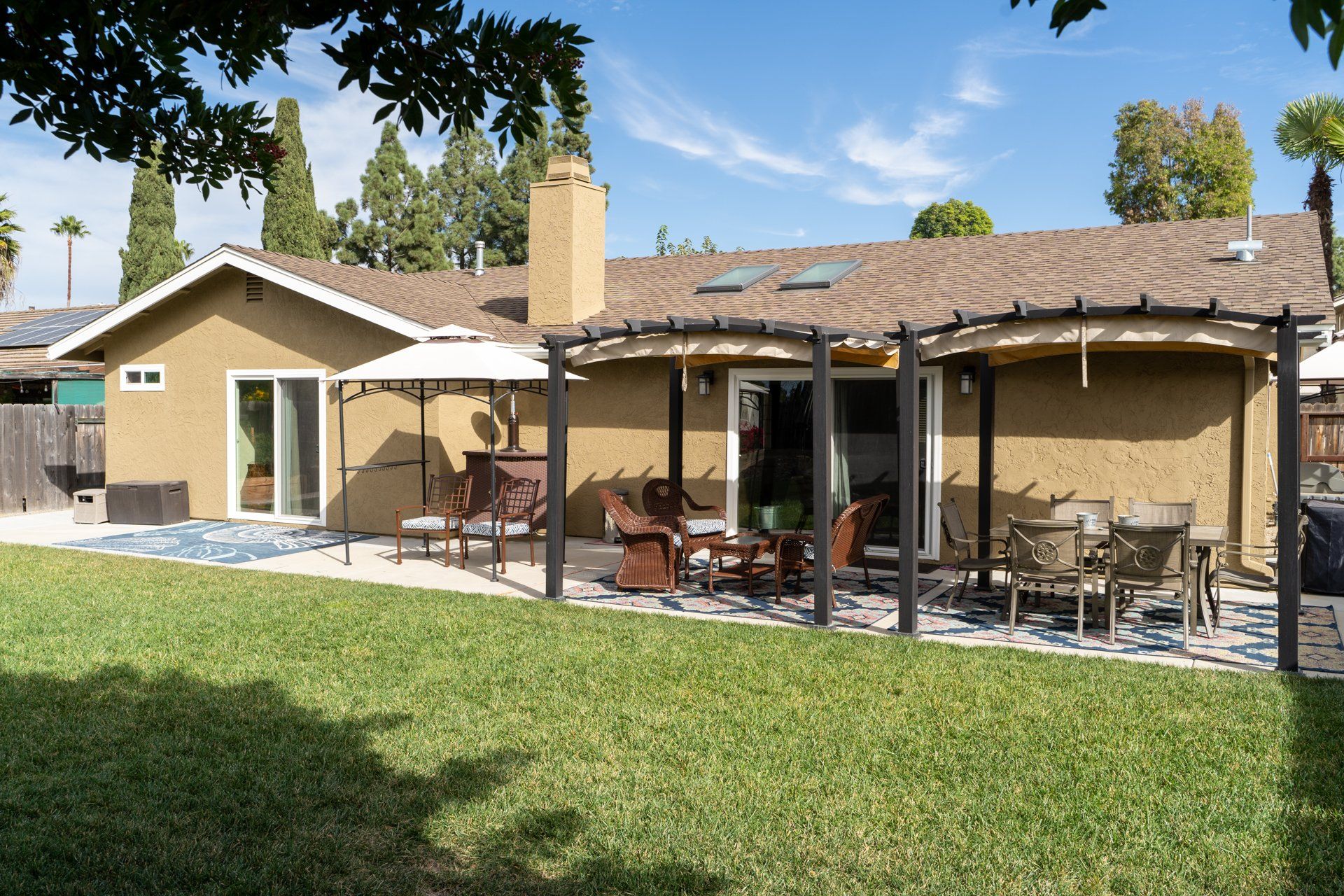 The backyard of a house with a pergola and patio furniture