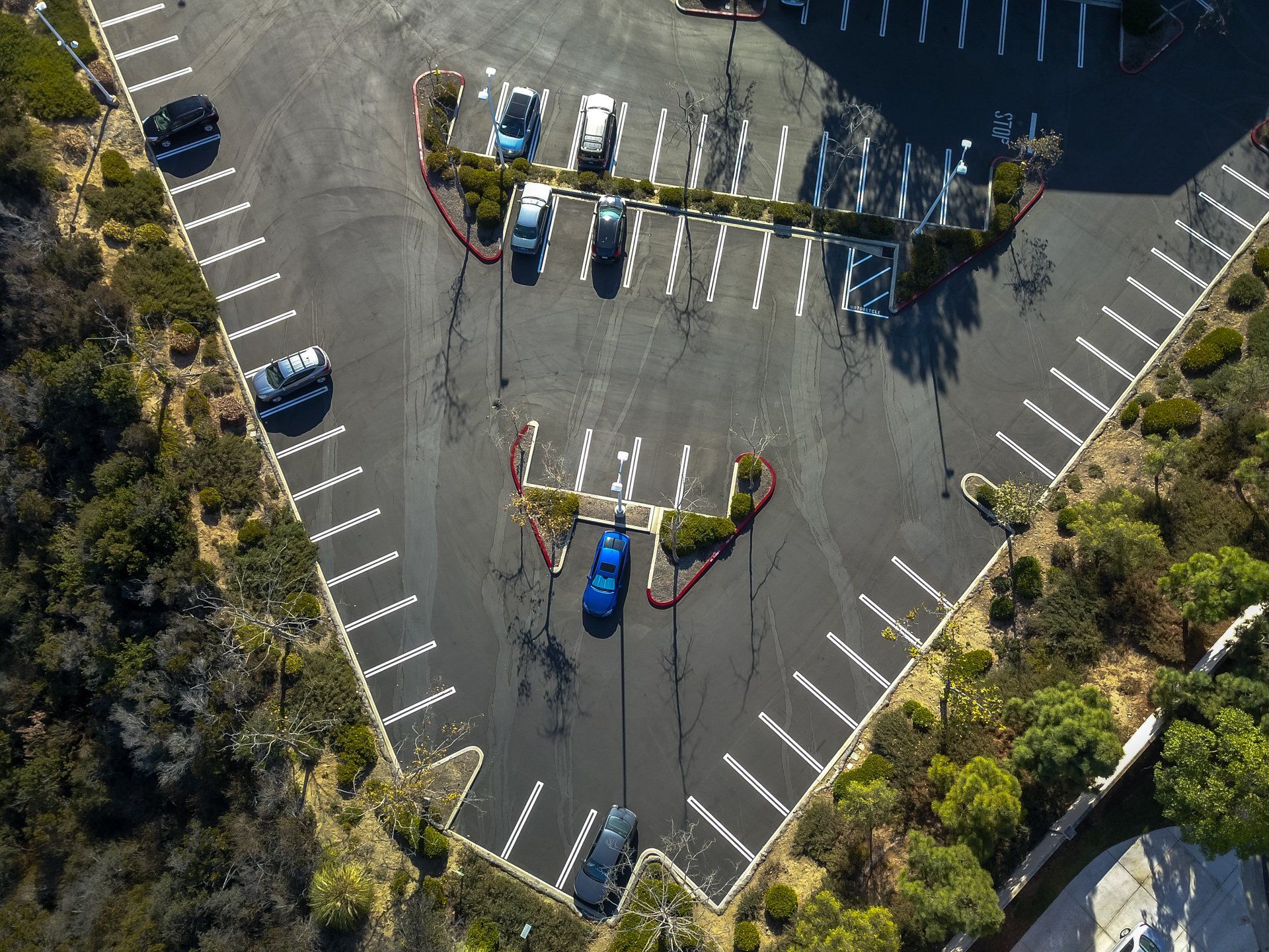 An aerial view of a parking lot with cars parked in it