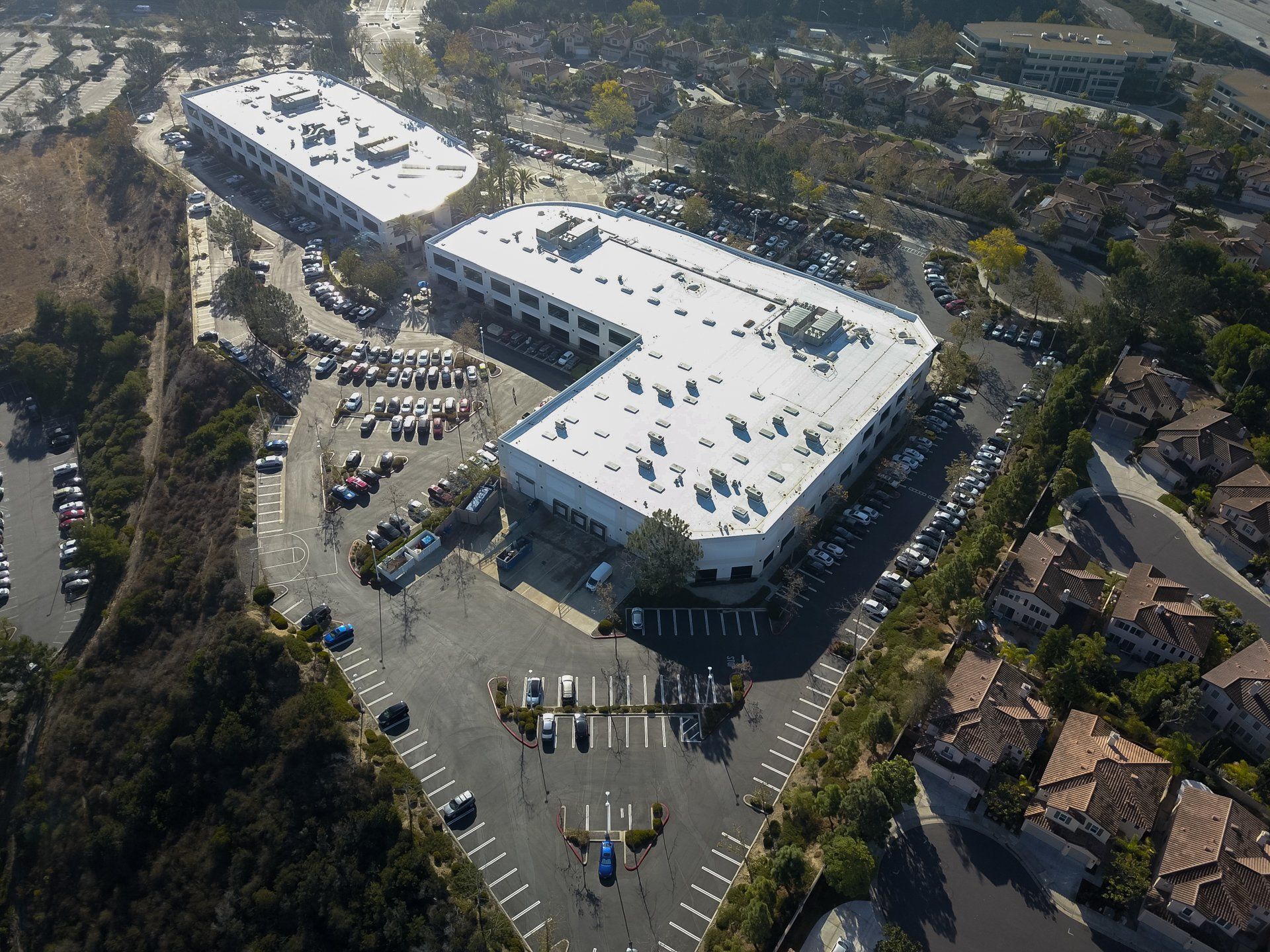 An aerial view of a large building with a white roof