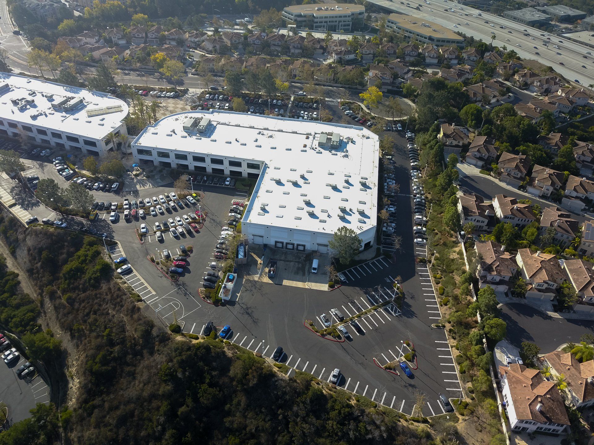 An aerial view of a large building with a white roof