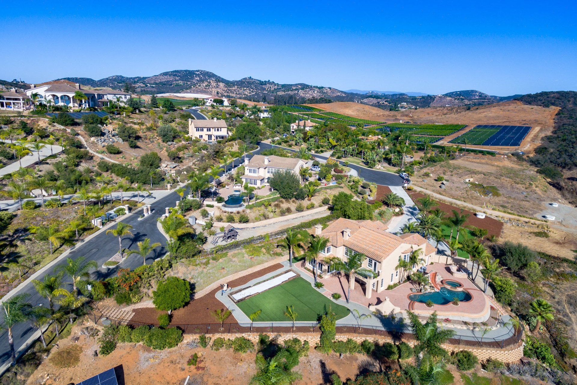 An aerial view of a residential area with a large house in the middle of it.