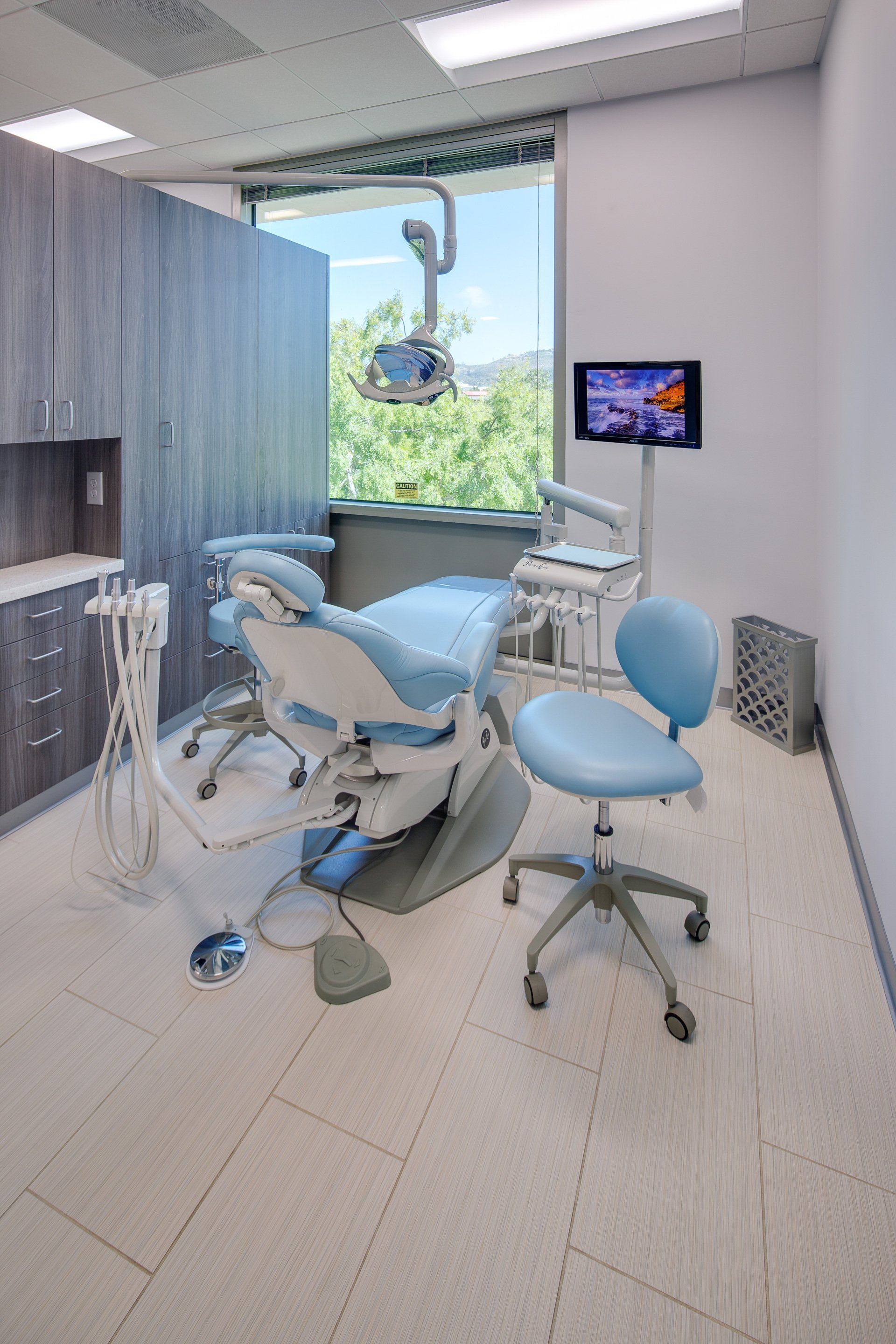 A dental office with a dental chair and a television.