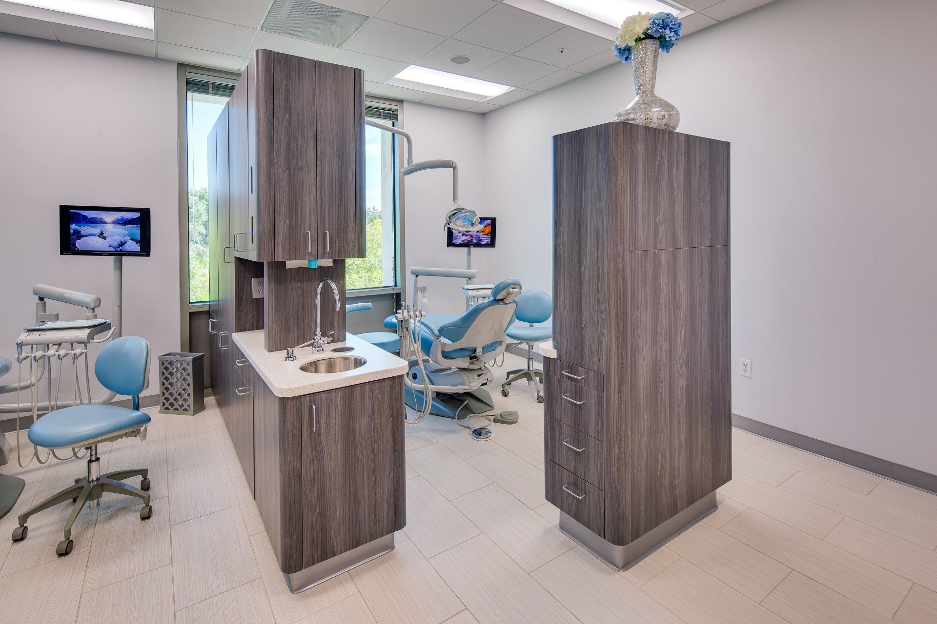 A dental office with a dental chair and a sink.