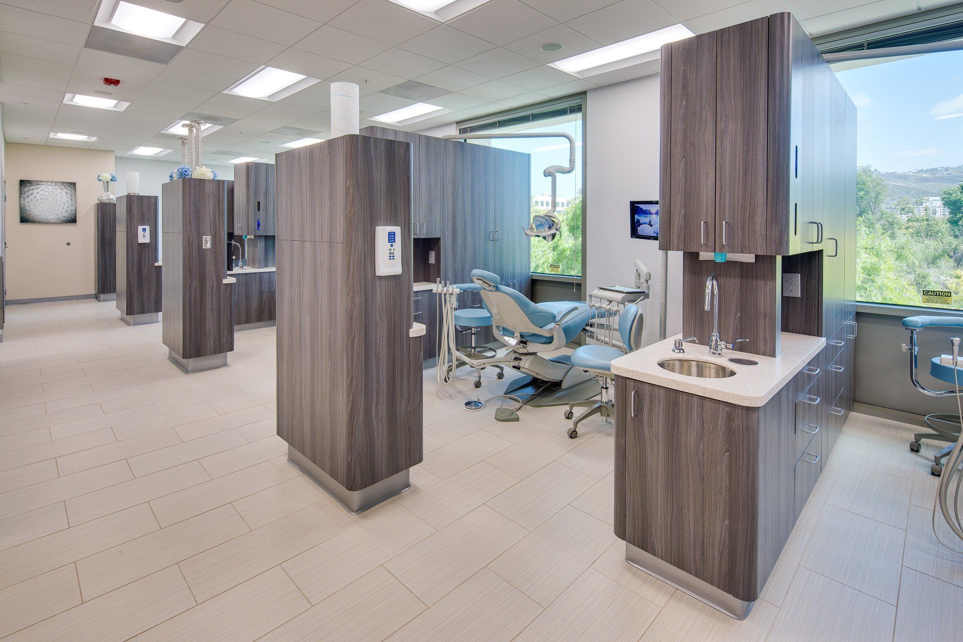 A dental office with a row of dental chairs and cabinets.