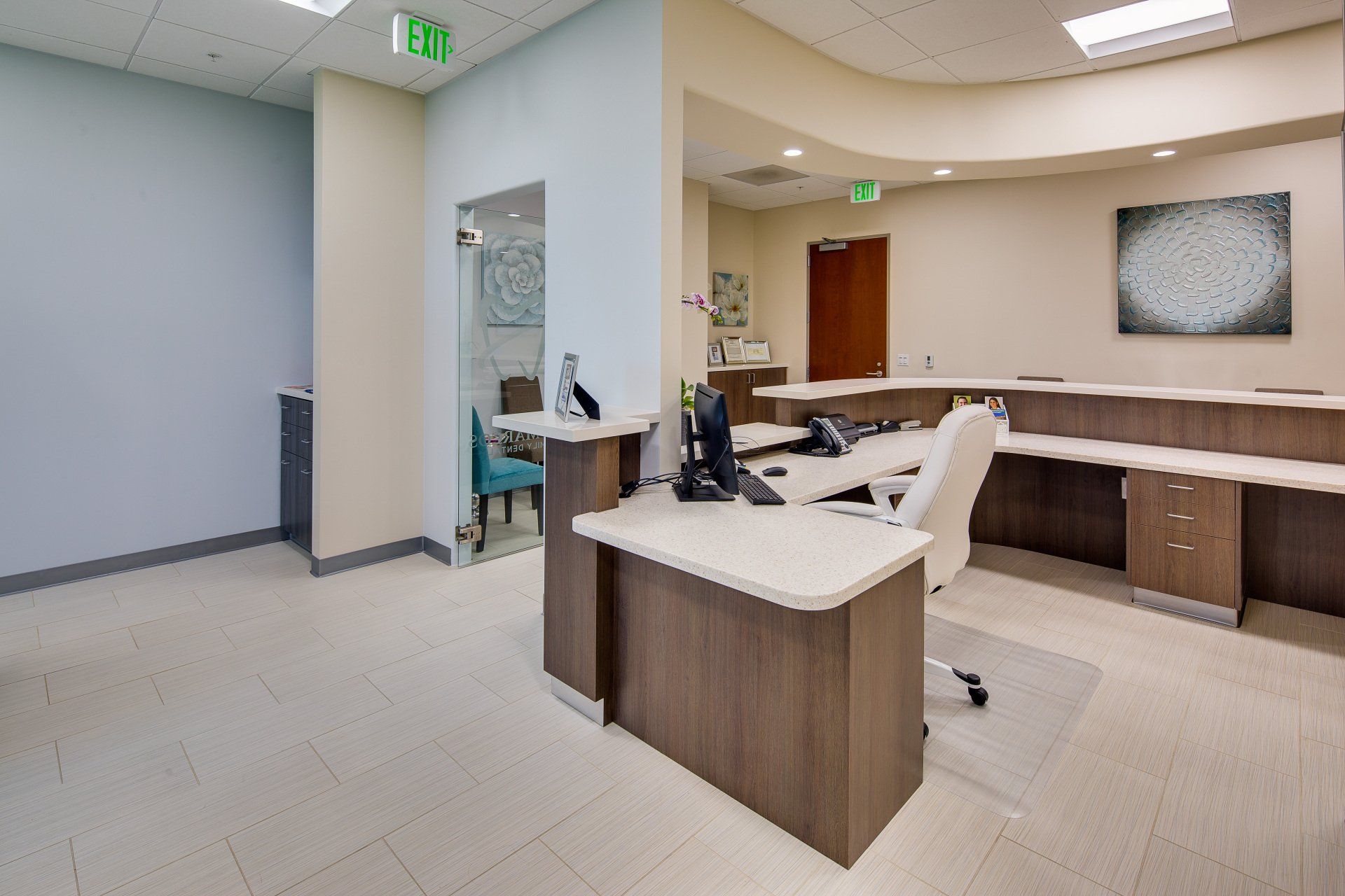 A hospital reception area with a desk , chair , and computer.
