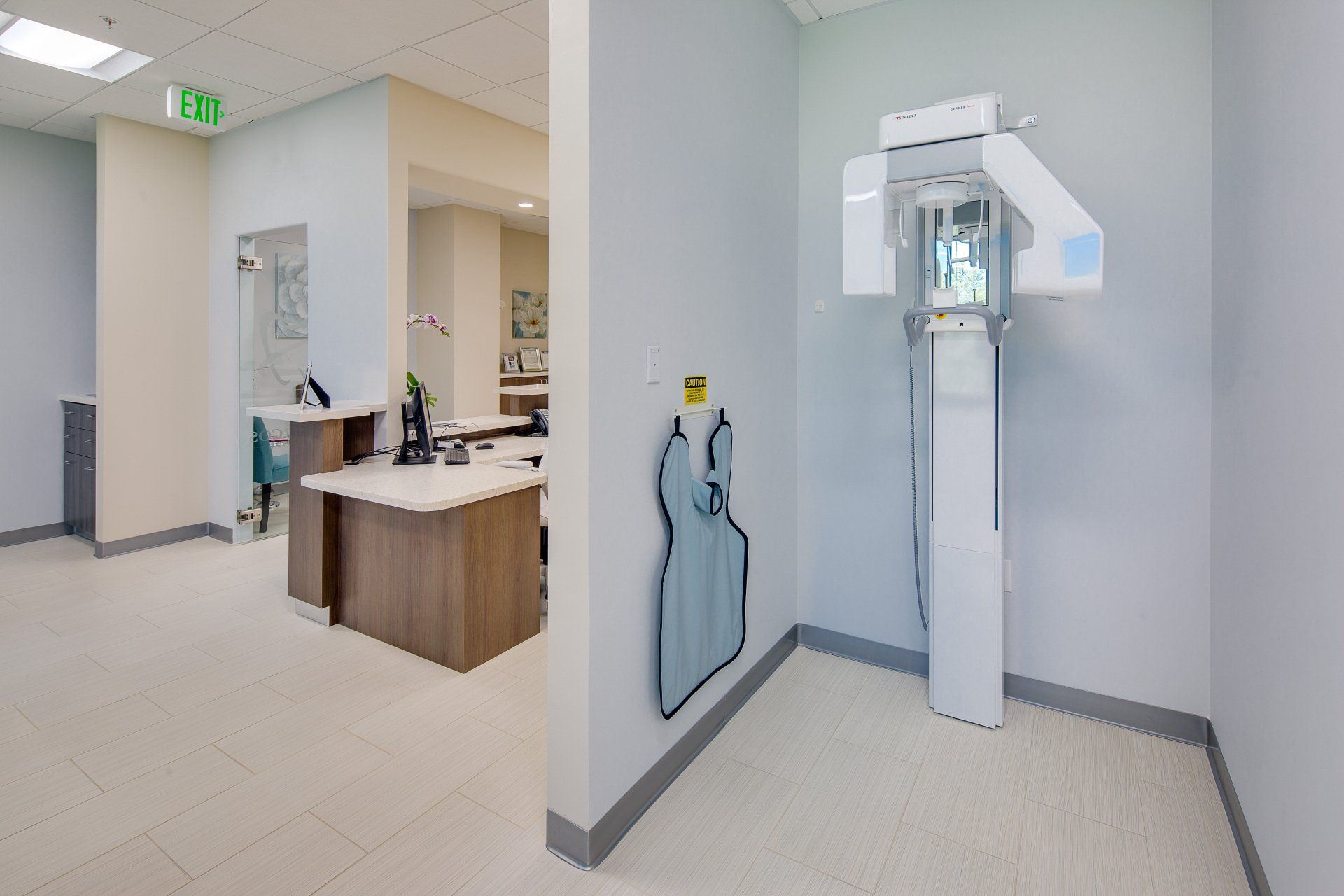 A dental office with a dental x-ray machine in the middle of the room.