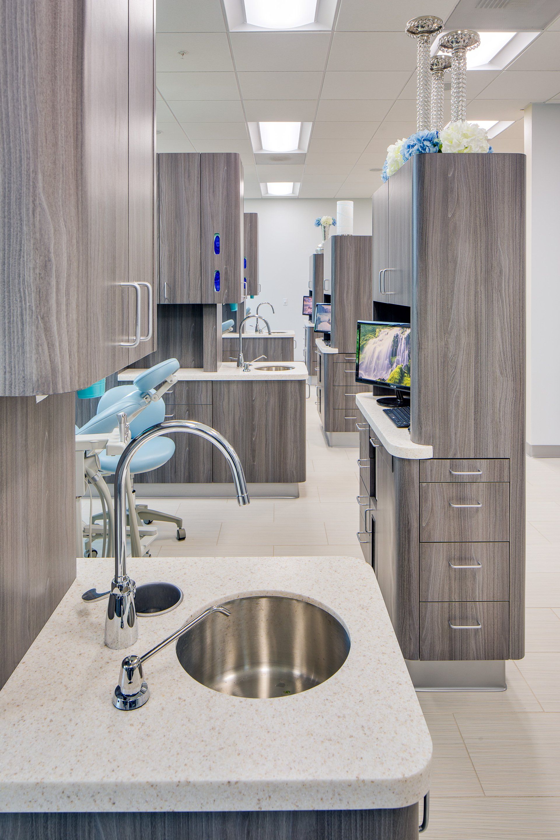 There is a sink in the middle of the room in a dental office.