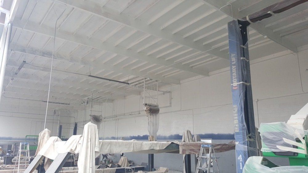 A large white building with a blue pole in the middle of it.